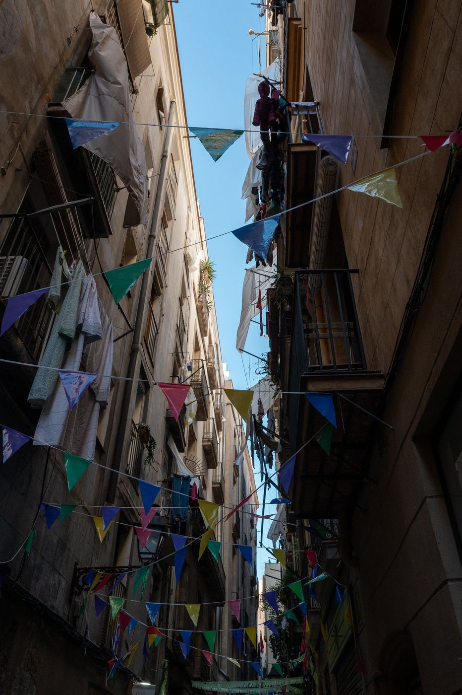 Garland of colorful pennants strung between two buildings, Barcelona