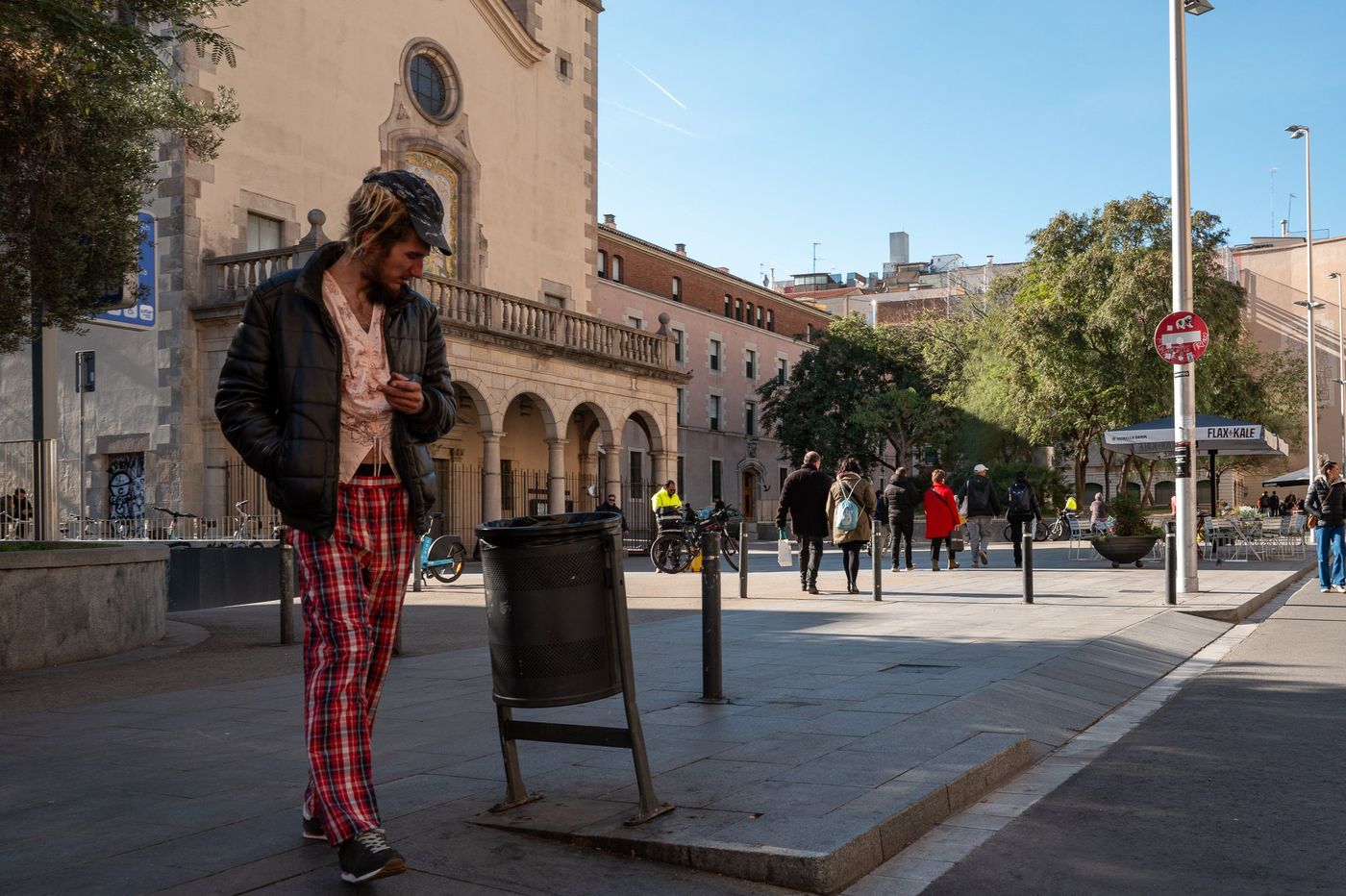 Woman in patterned trousers crossing a square, Barcelona