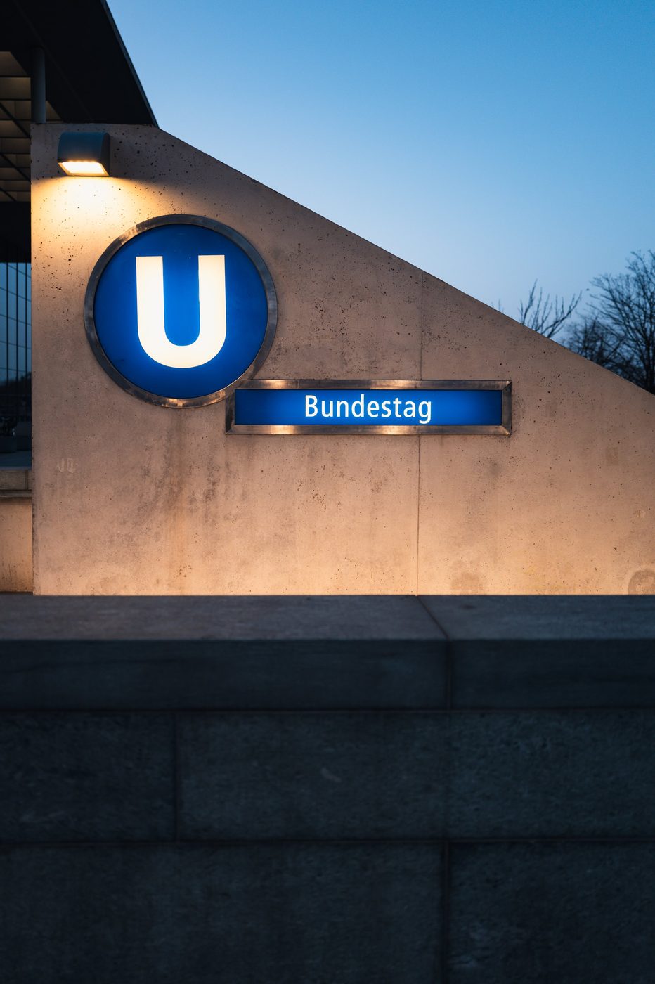 Blue sign of the Bundestag subway station illuminated at dusk, Berlin