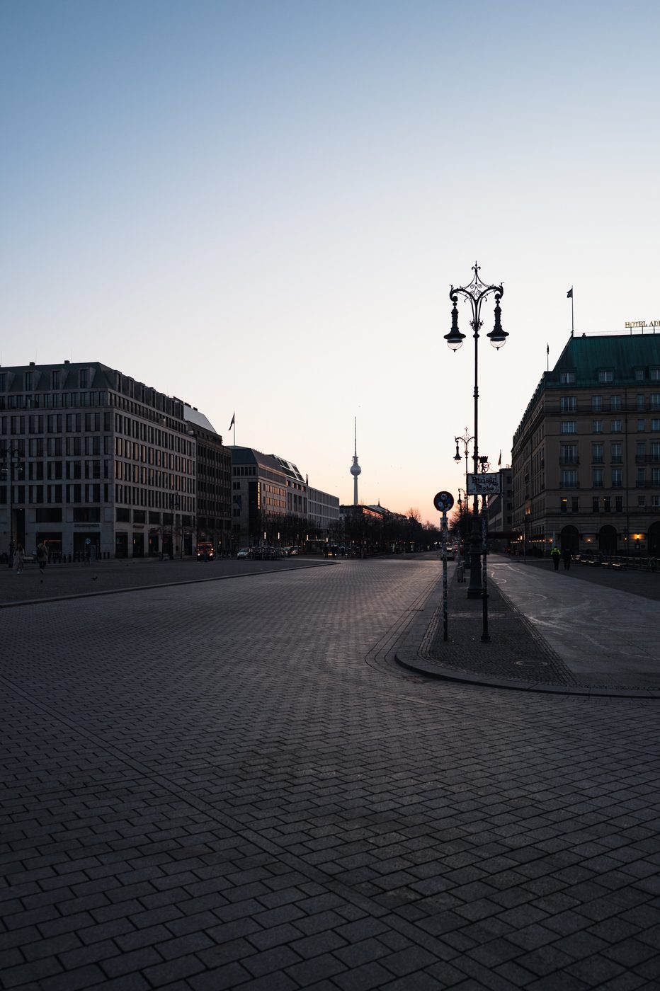 Ornate street lamp and avenue perspective toward the television tower at dusk, Berlin