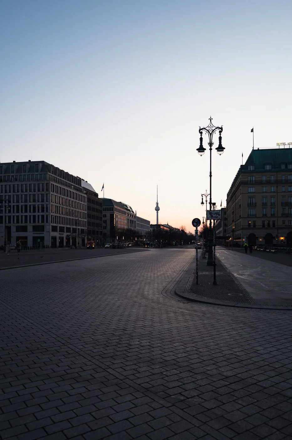 Réverbère ouvragé et perspective de l'avenue vers la tour de télévision au crépuscule, Berlin