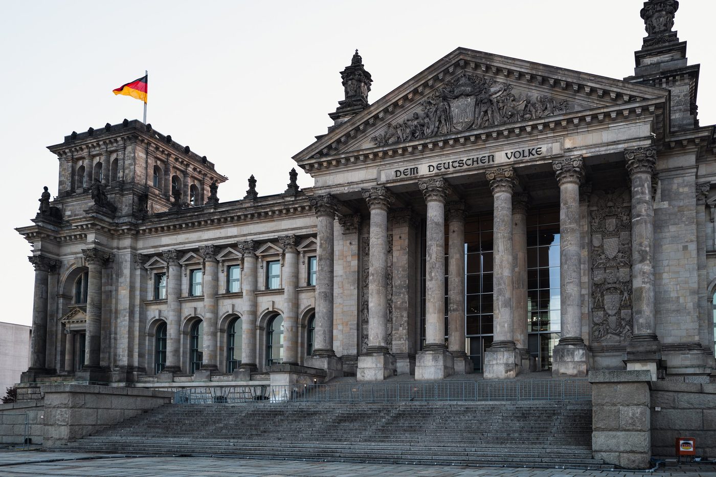 Pediment of the Reichstag with its inscription 'Dem deutschen Volke' beneath a German flag, Berlin