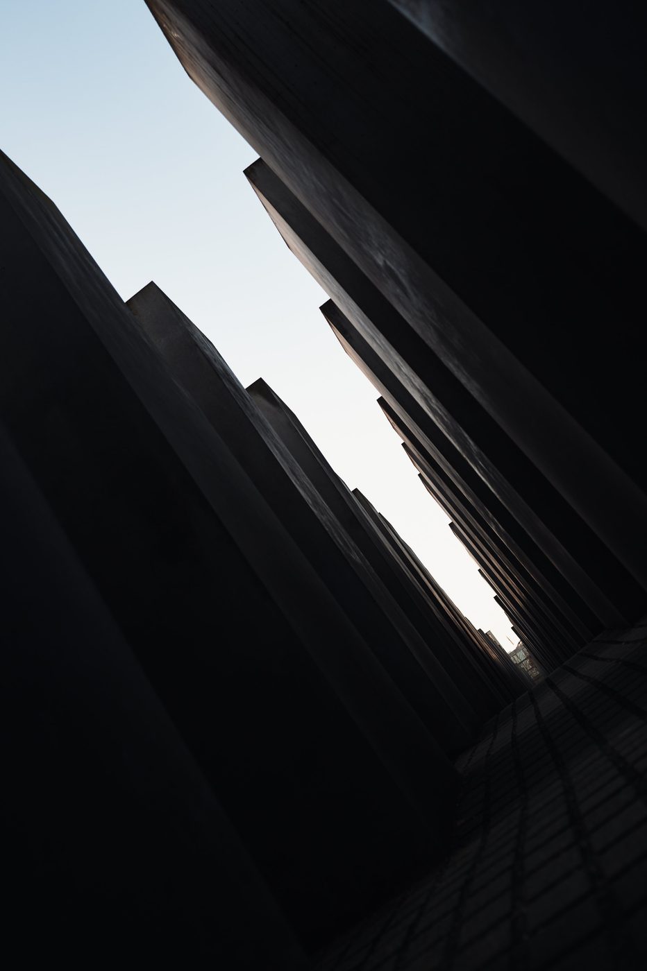 Dark, oblique perspective between the tilted slabs of the memorial, Berlin
