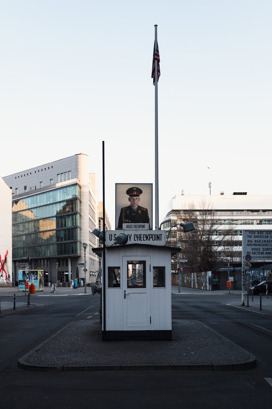 Checkpoint Charlie guardhouse flanked by the American flag and a soldier's portrait, Berlin