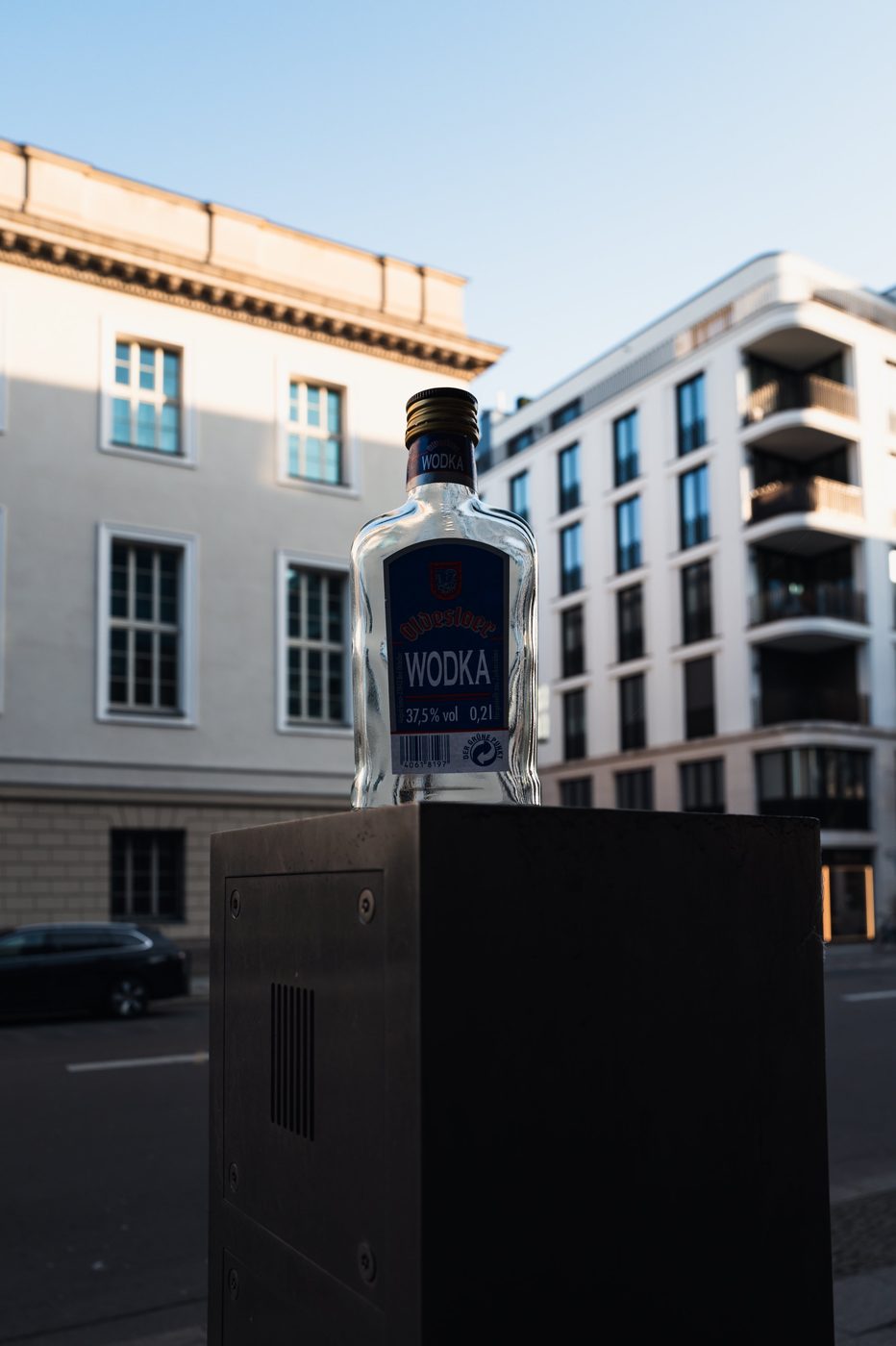 Small vodka bottle prominently placed on a street bollard, Berlin