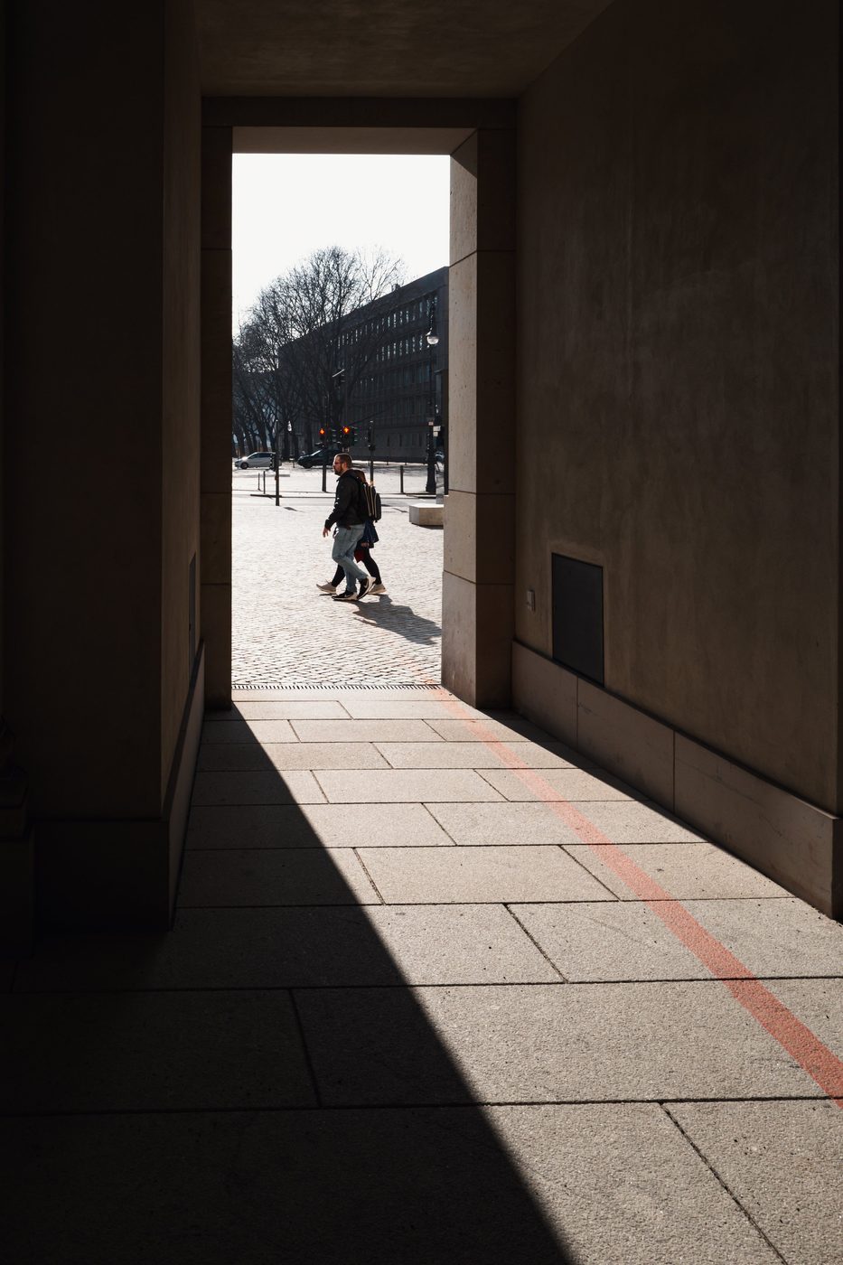 Silhouettes of passersby in the luminous frame of a porch, Berlin