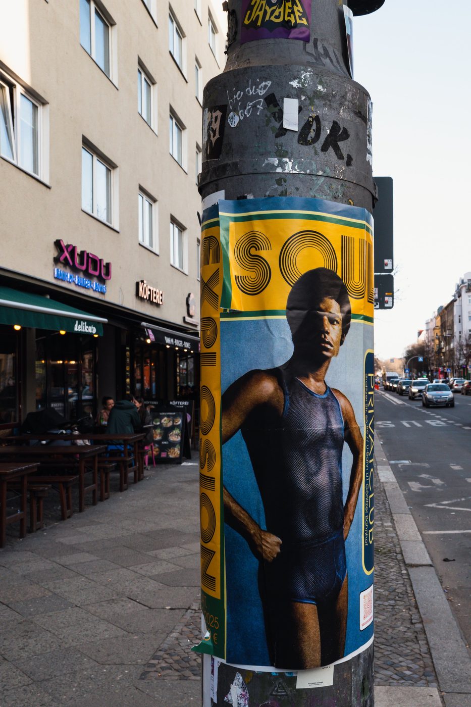 Vintage soul music poster pasted on a lamppost above a shopping street, Berlin