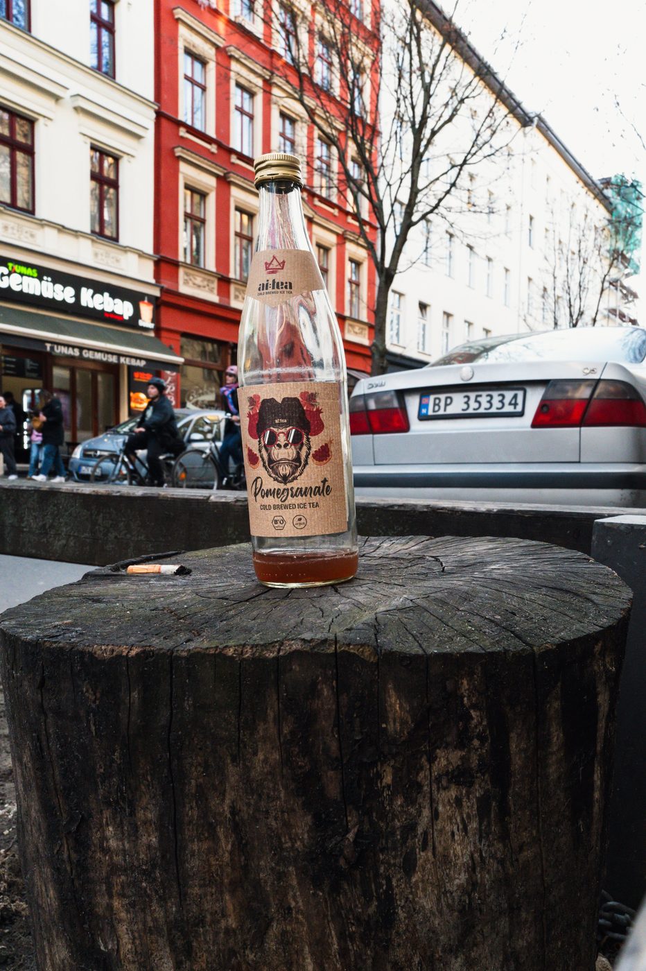 Iced tea bottle labeled with a gorilla, resting on a tree stump, Berlin