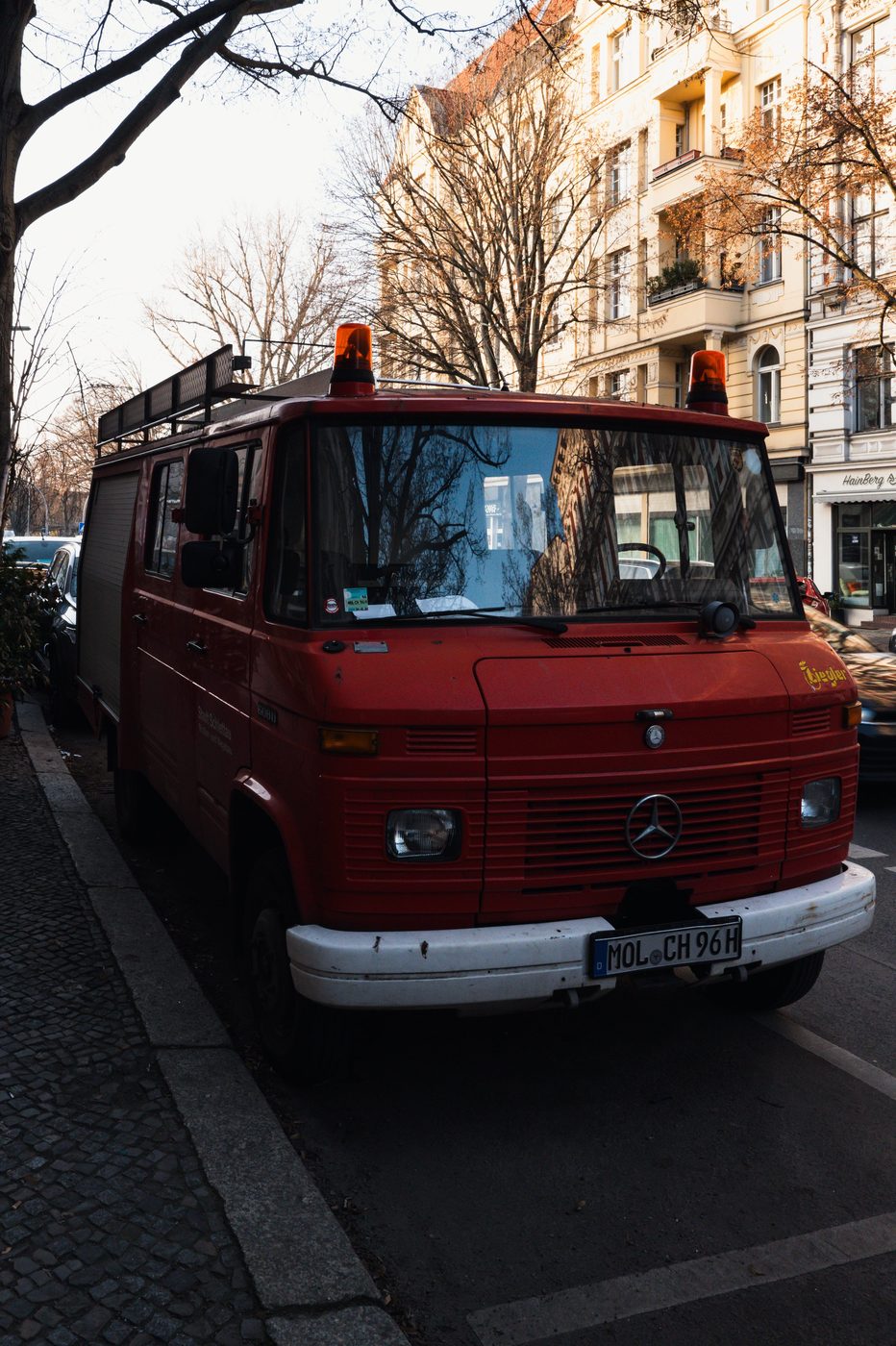 Old red fire truck parked along a residential street, Berlin