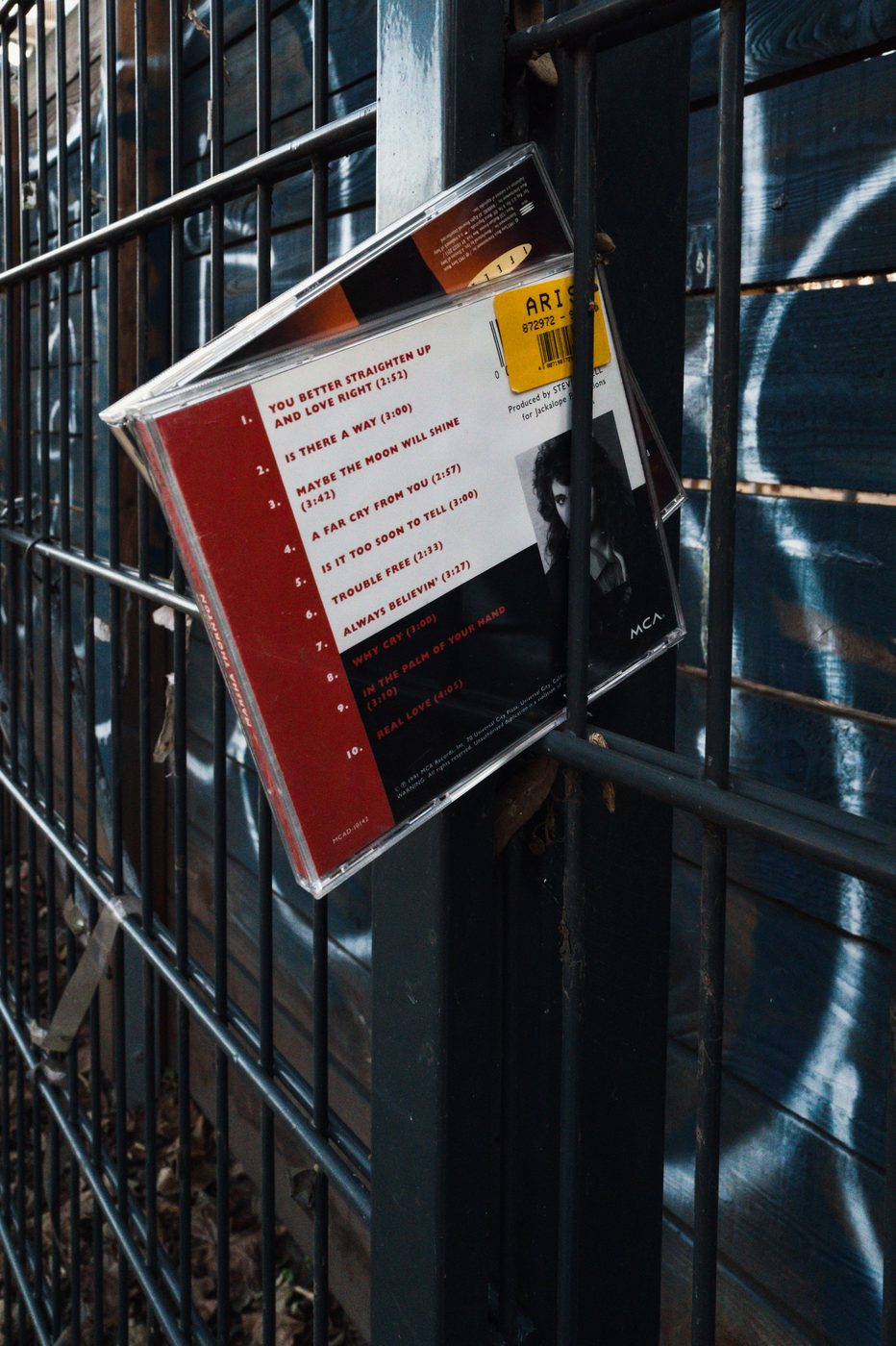 Abandoned open CD case hanging on a metal grate, Berlin