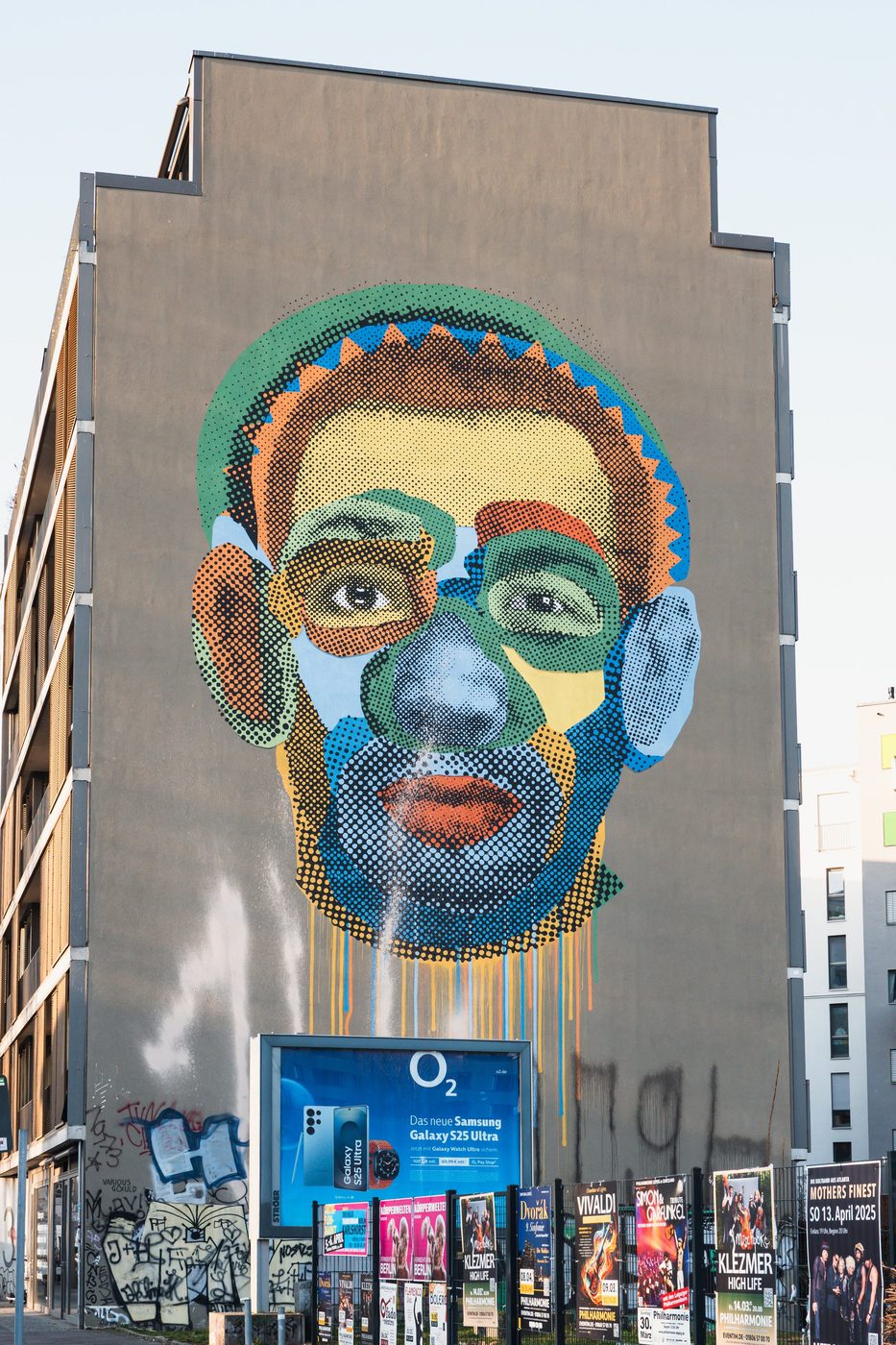 Pixelated, colorful mural portrait covering the facade of a building, Berlin