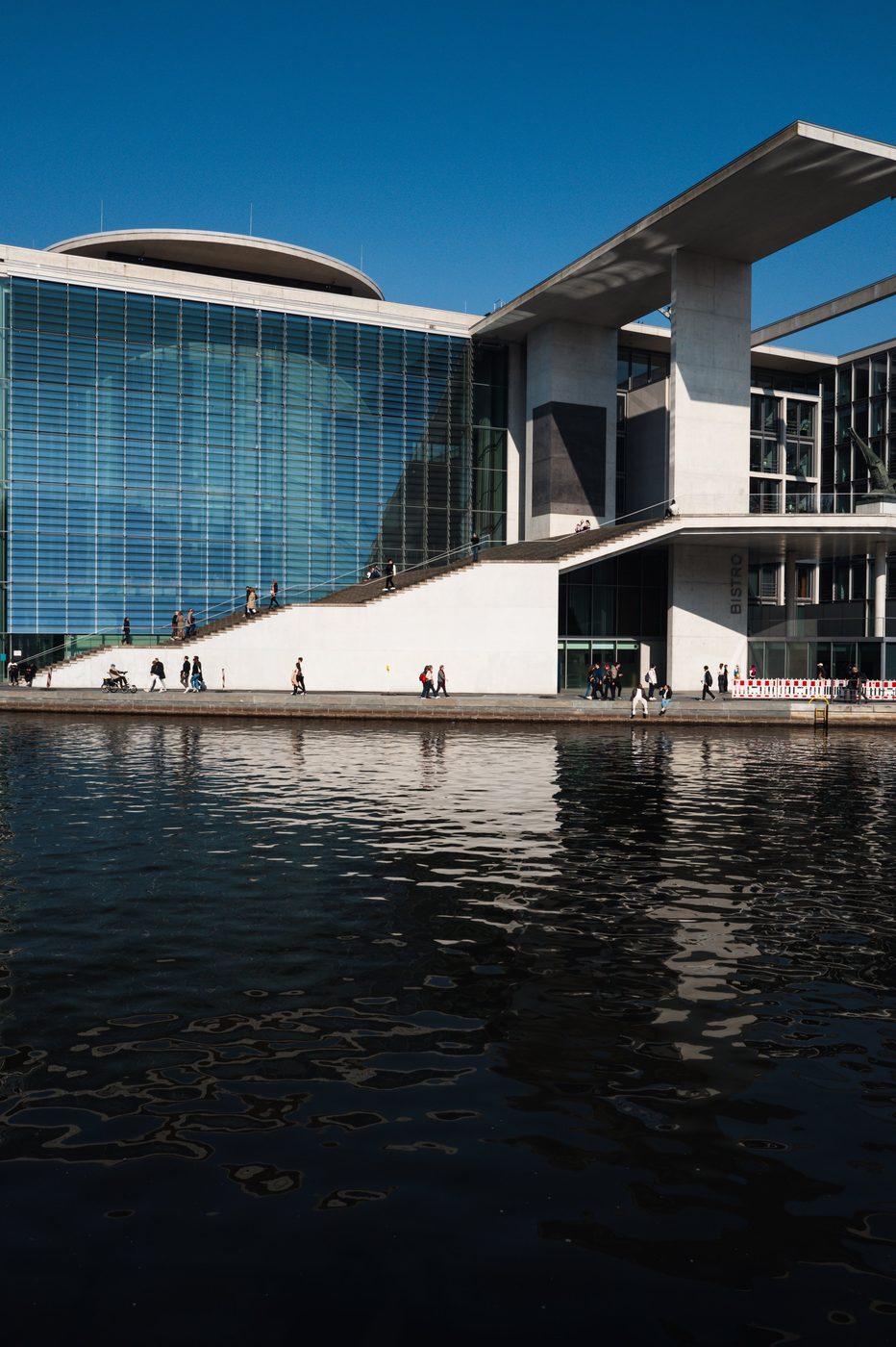 Monumental staircase and glass facade of the Bundestag, passersby on the steps, Berlin