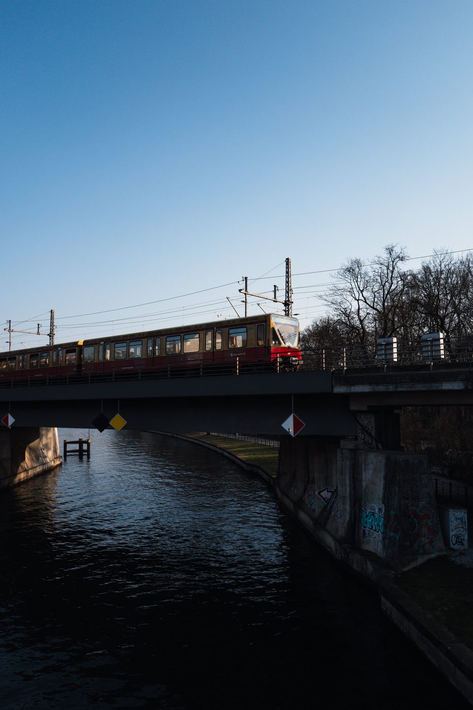Regional train crossing a metal bridge over a canal, Berlin
