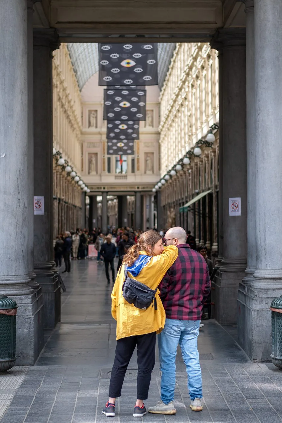 Couple enlacé à l’entrée d’une galerie couverte à colonnades, Bruxelles