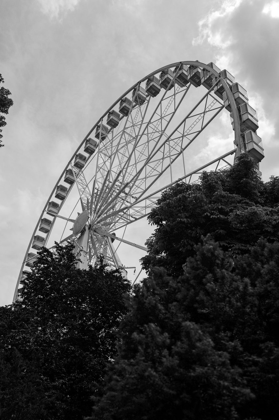 Ferris wheel seen from below behind the treetops, Budapest