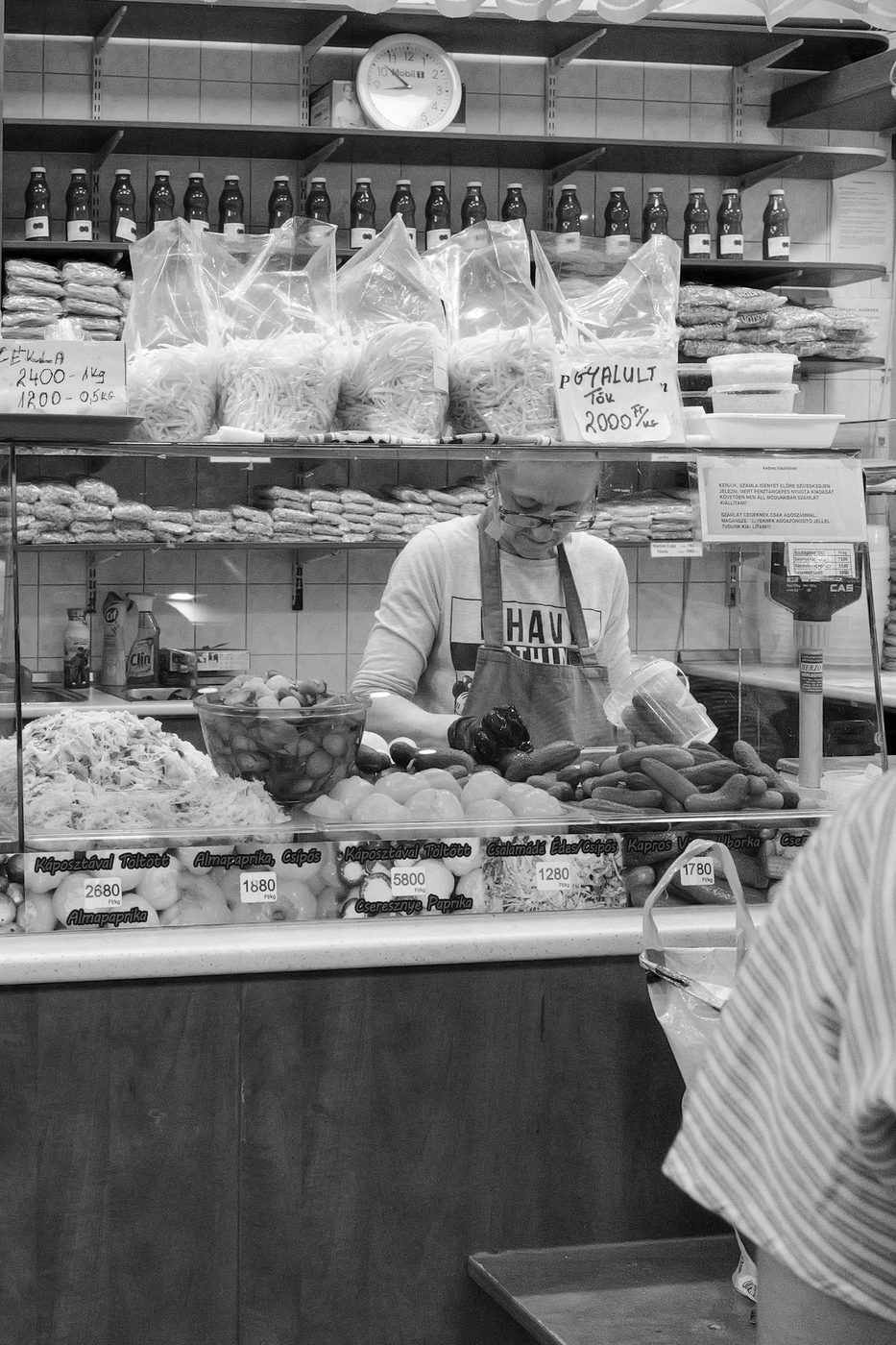 A butcher preparing pickles behind his counter, Budapest