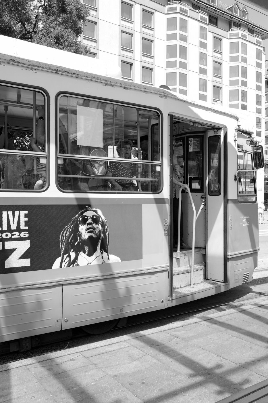 Portrait displayed on the side of a tram with open doors, Budapest