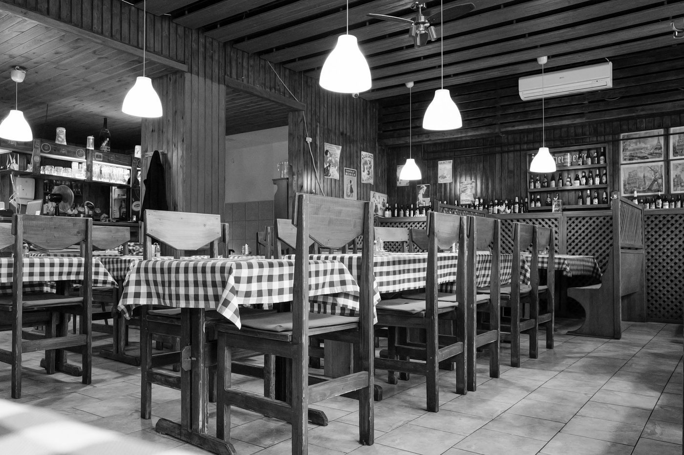 Empty restaurant room with checkered tablecloths and hanging lights, Budapest