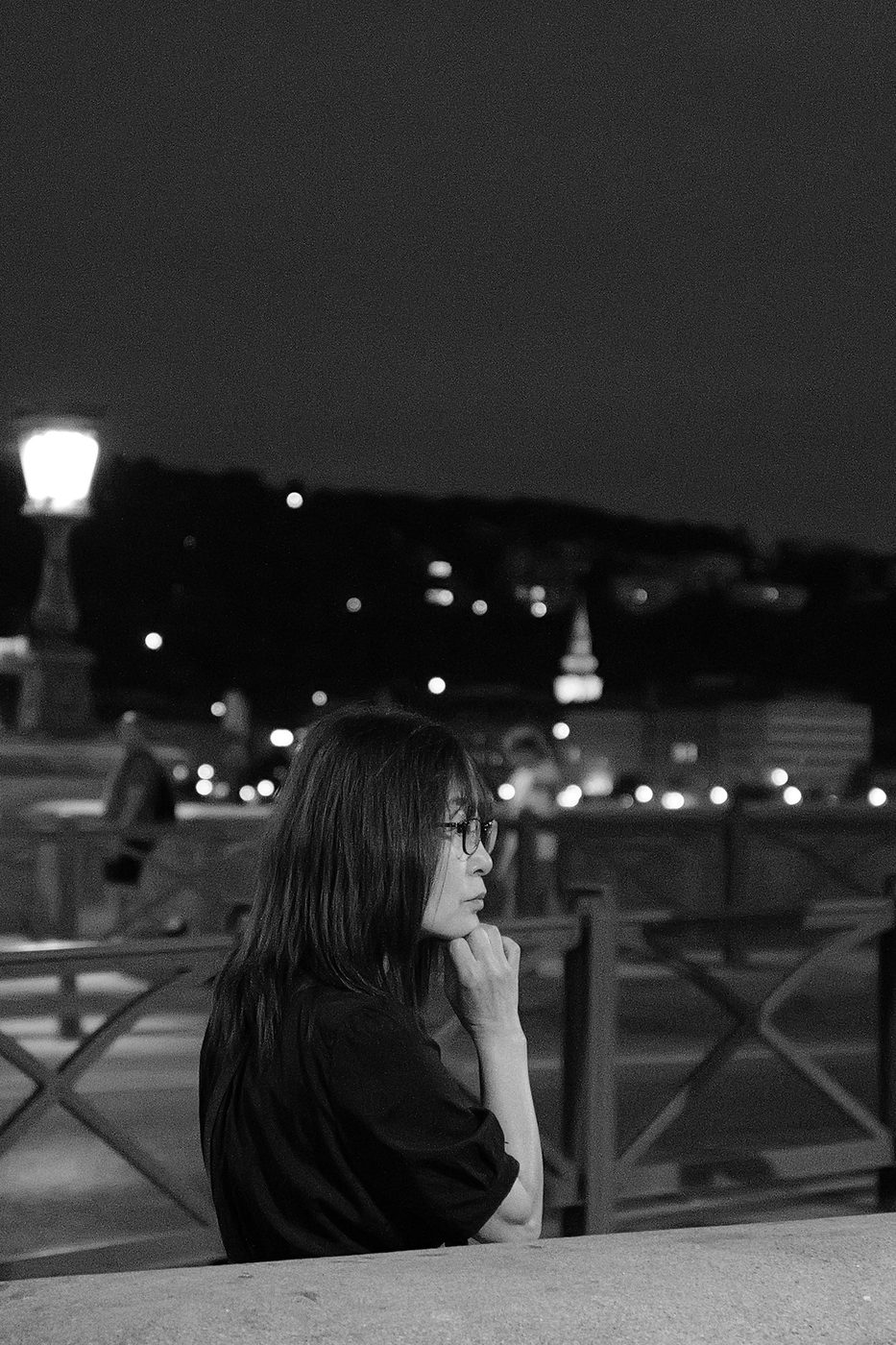 Night portrait of a pensive woman leaning on a parapet, Budapest