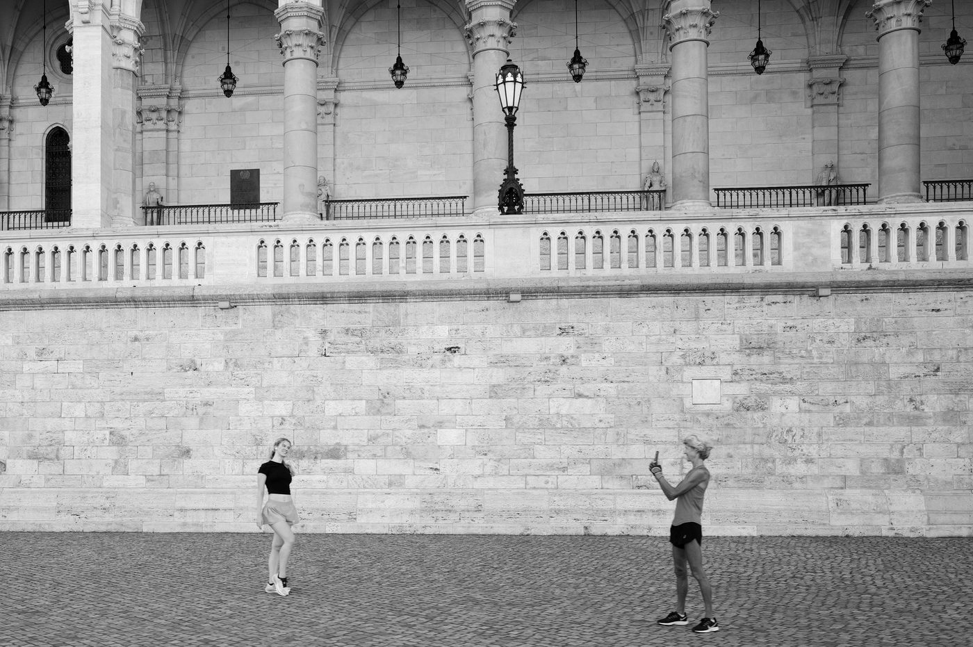 Two joggers photographing themselves in front of the Bastion's arcades, Budapest