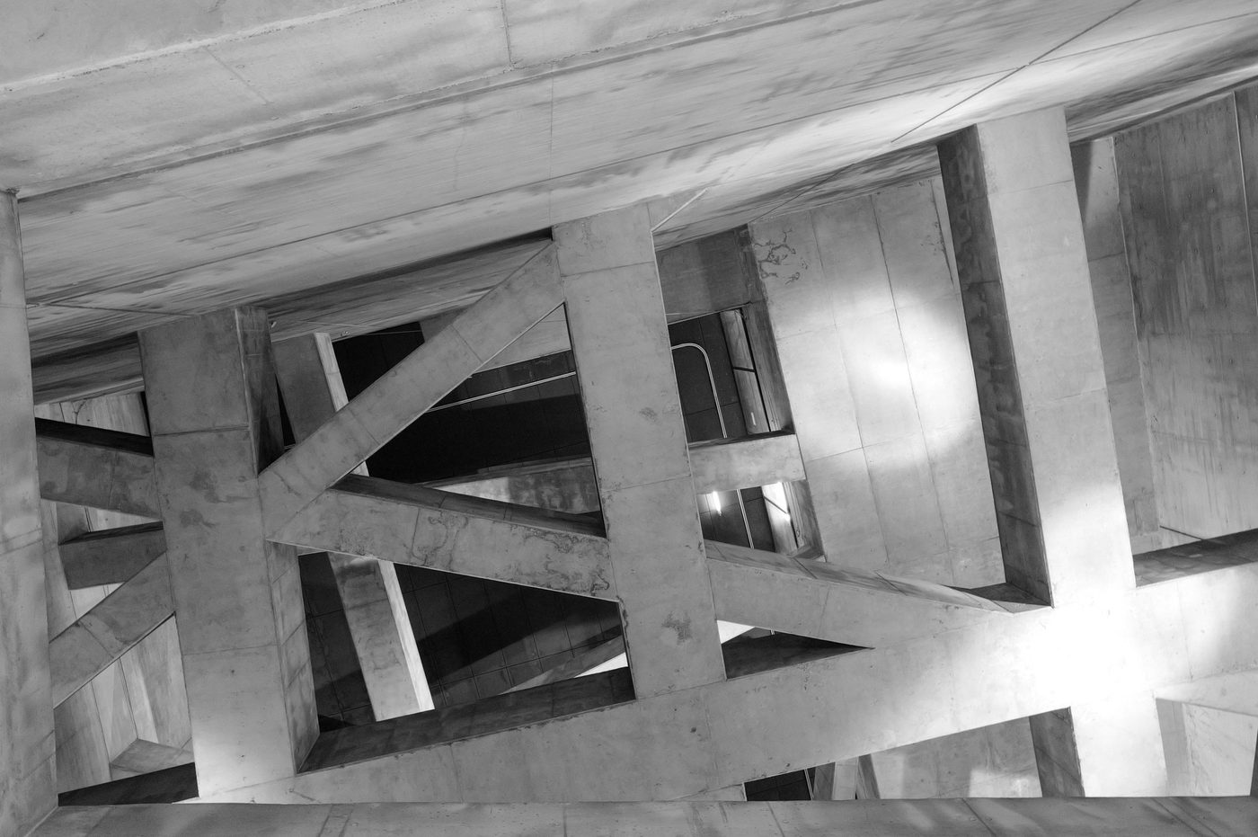 Crisscrossing concrete beams seen from below in a stairwell, Budapest