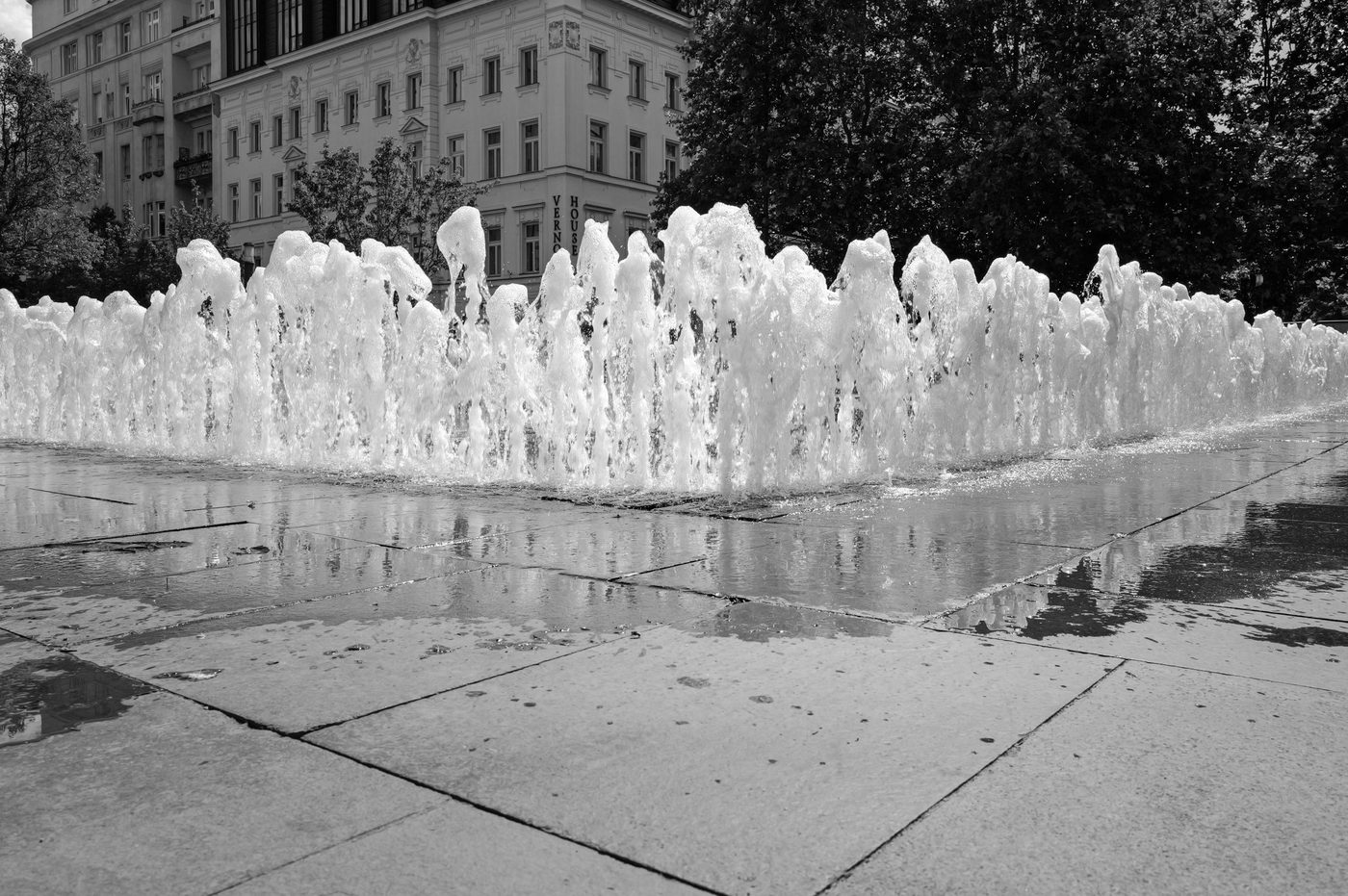 Row of misty water jets in front of a richly ornate facade, Budapest