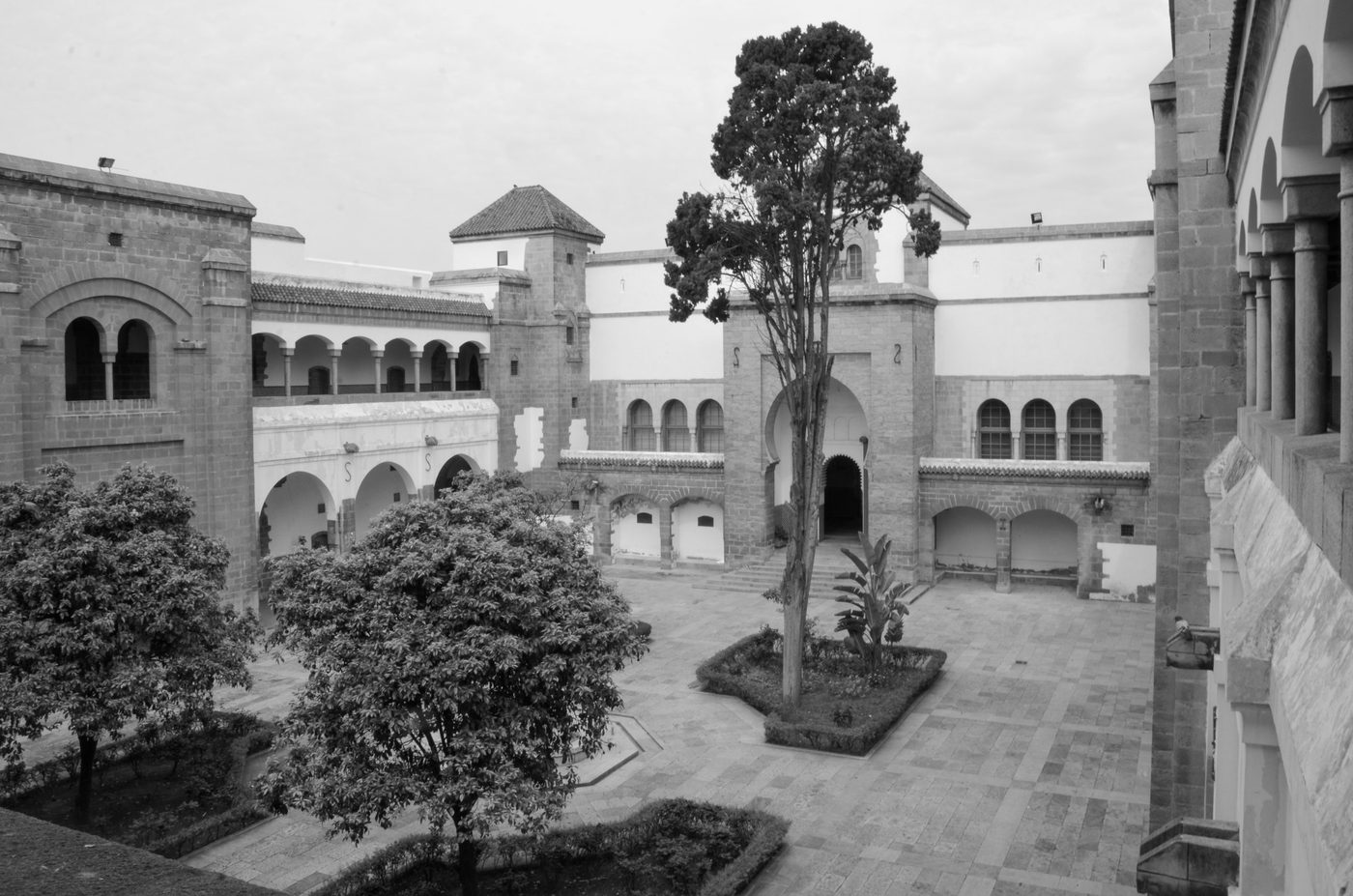 Tree-lined interior courtyard bordered by arcades and a tower, Casablanca