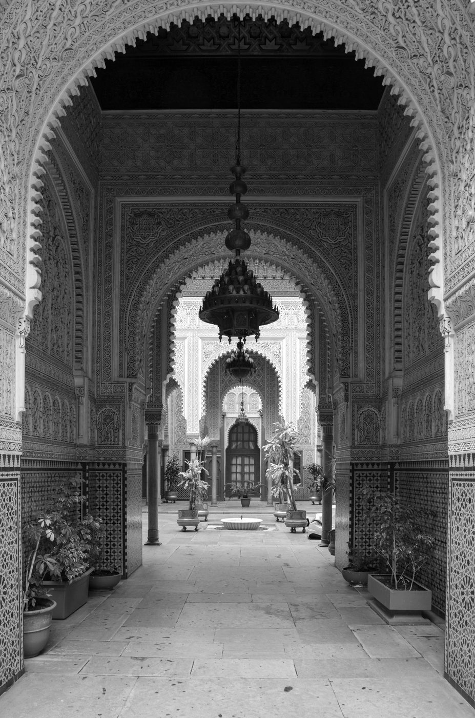 Row of carved arches and hanging chandeliers leading to an interior courtyard, Casablanca