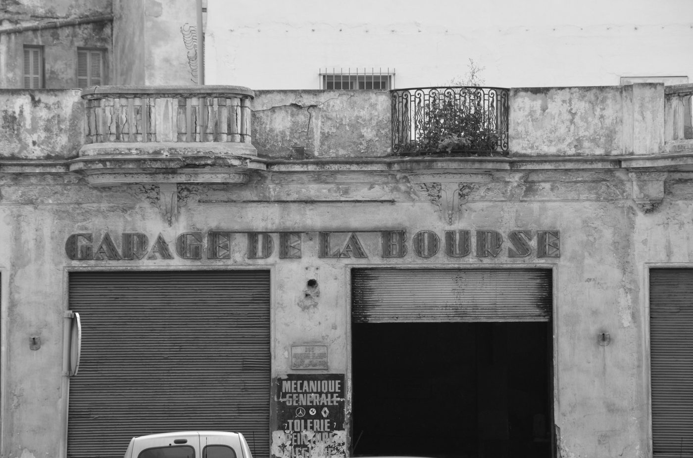Faded sign of the Garage de la Bourse on a crumbling facade, Casablanca
