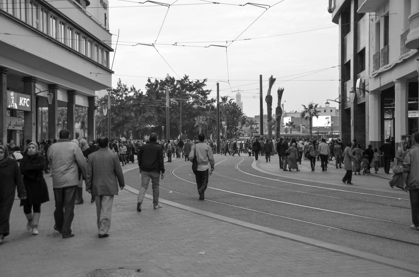 Crowd on a busy avenue beneath a tangle of cables, Casablanca