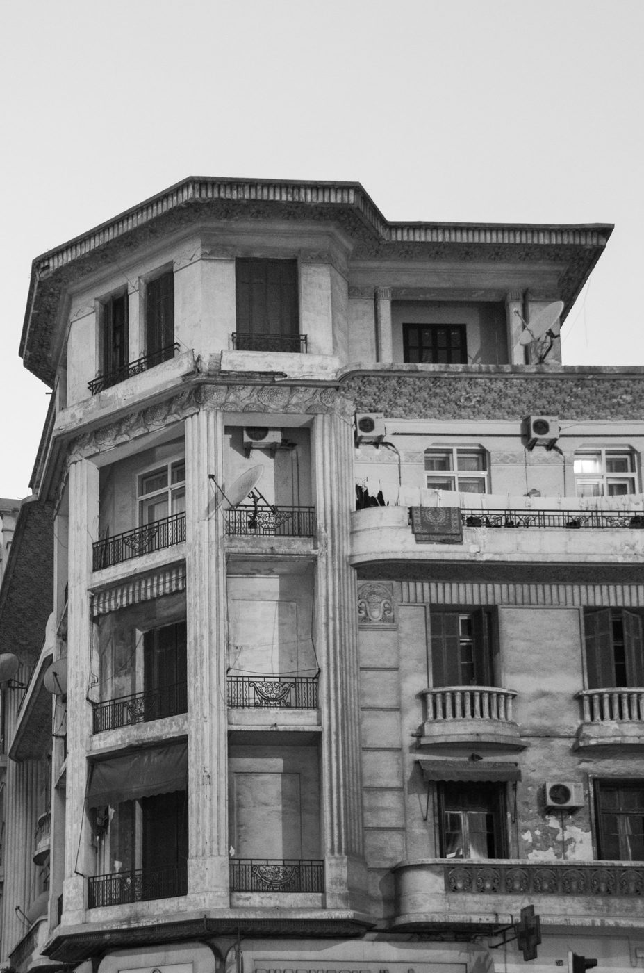 Weathered corner building with stacked balconies and satellite dishes, Casablanca