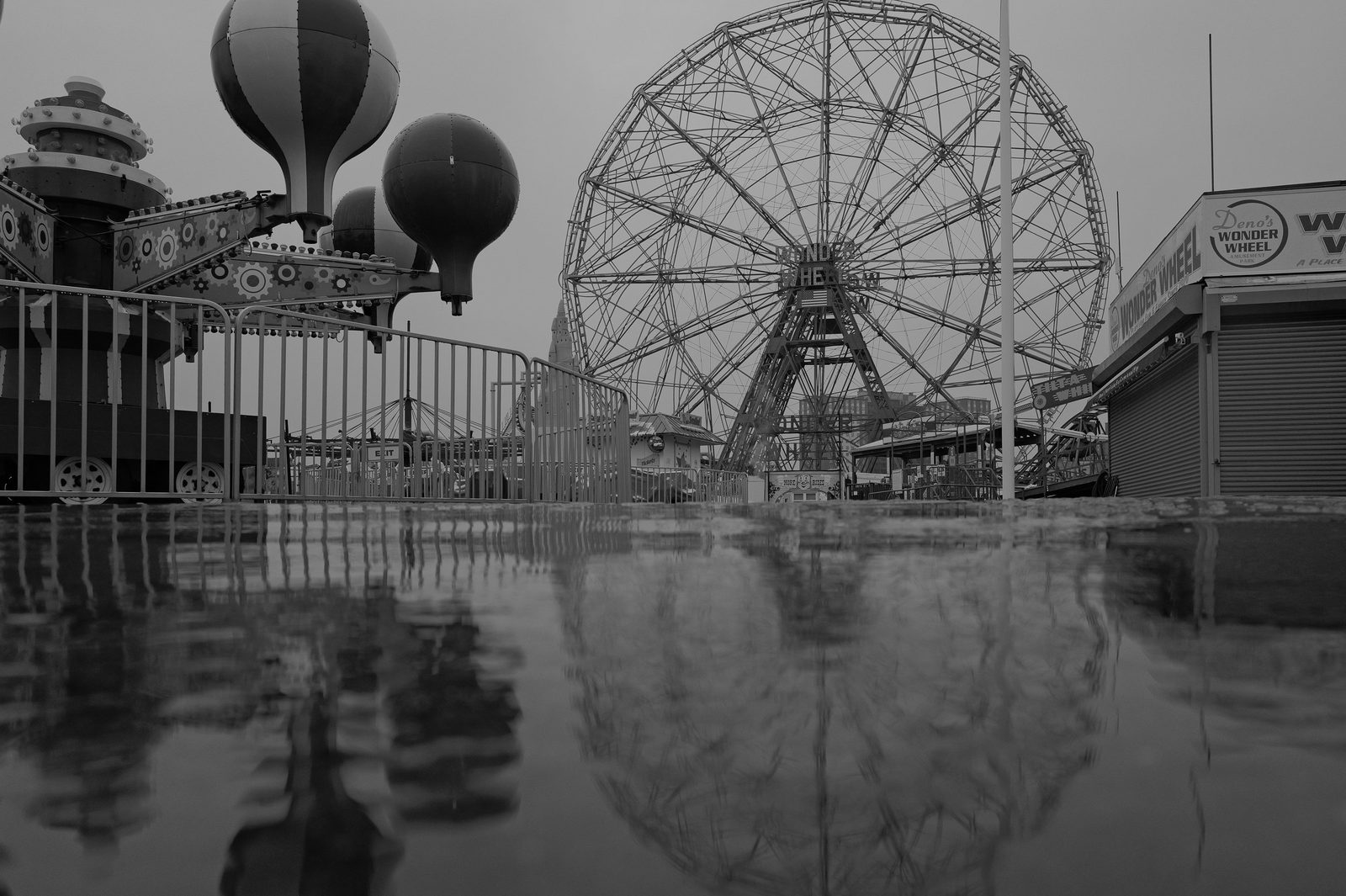 Ferris wheel and amusement park reflected on wet ground, Coney Island