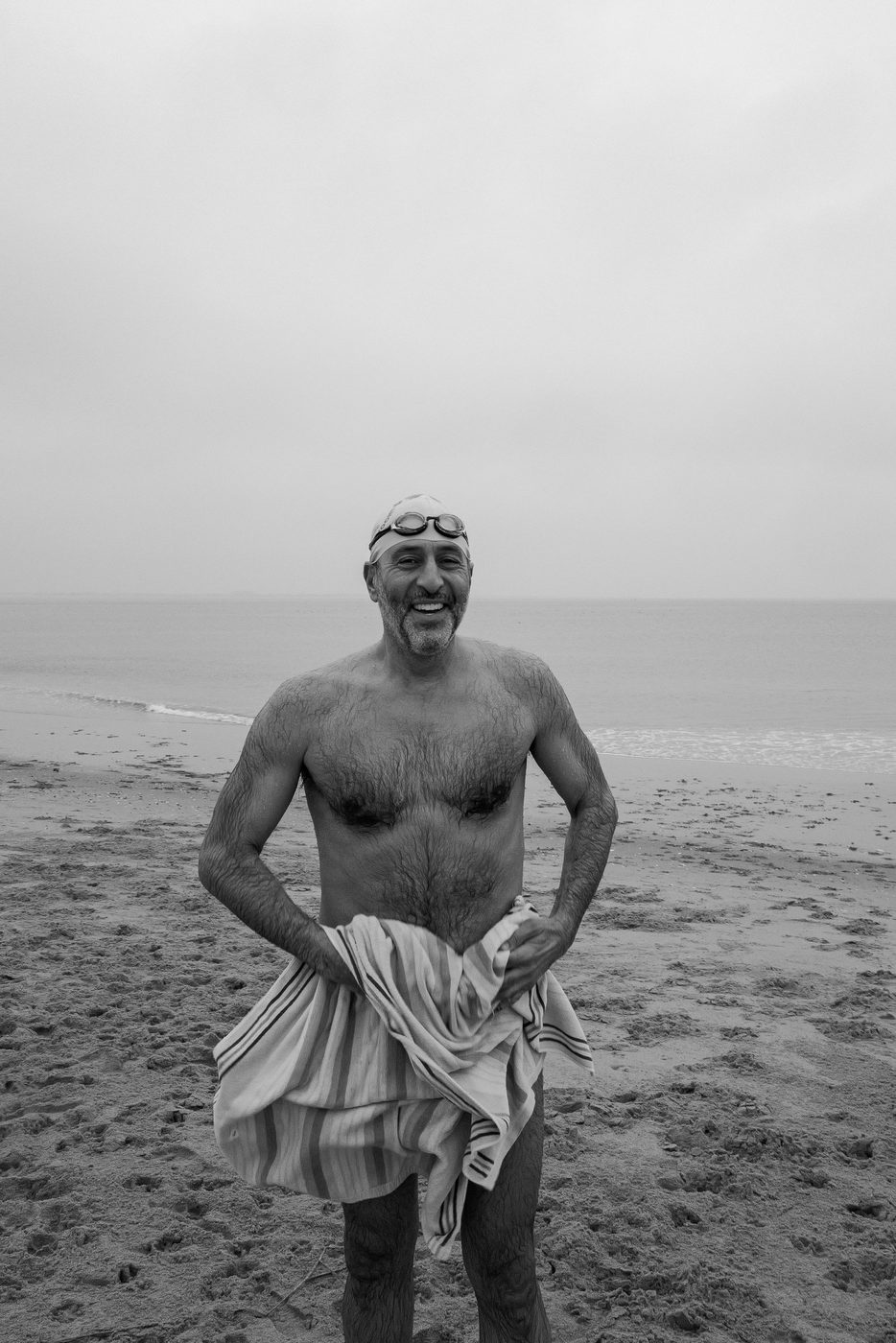 Smiling swimmer drying off with a striped towel, Coney Island