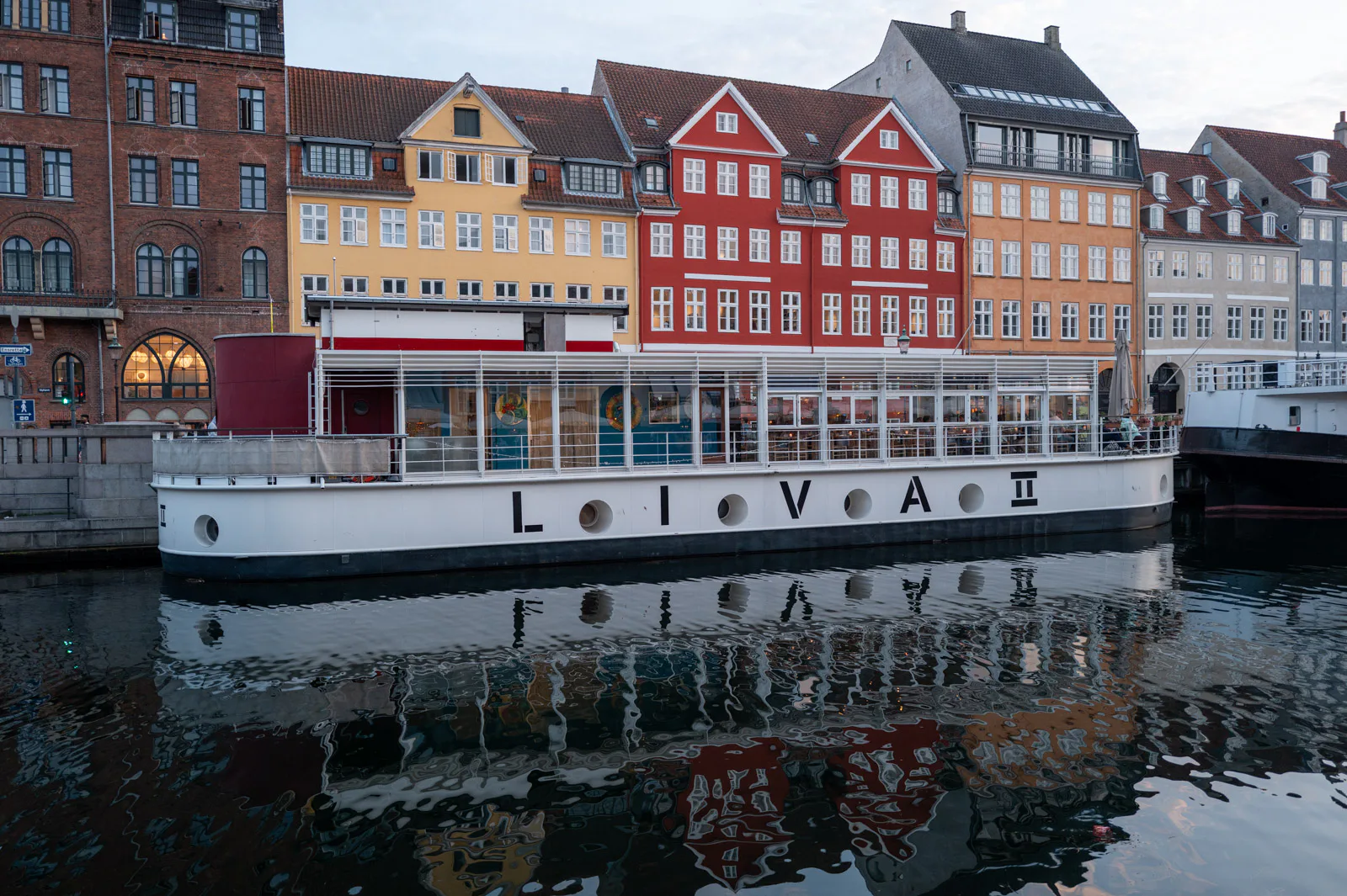 The Liva II boat moored in front of the colourful facades of Nyhavn, Copenhagen