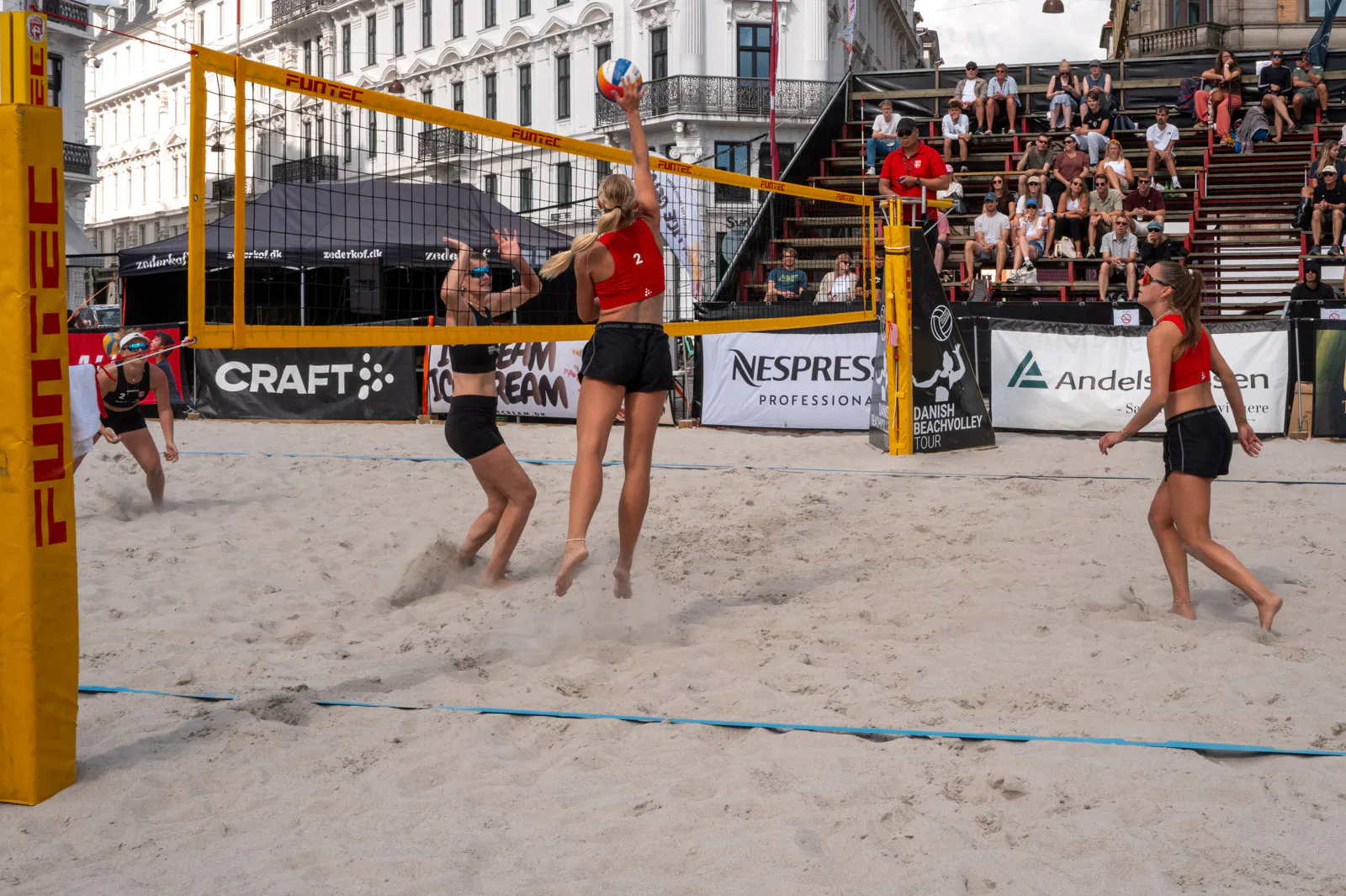 A spike at the net of a beach volleyball tournament, in front of the stands, Copenhagen
