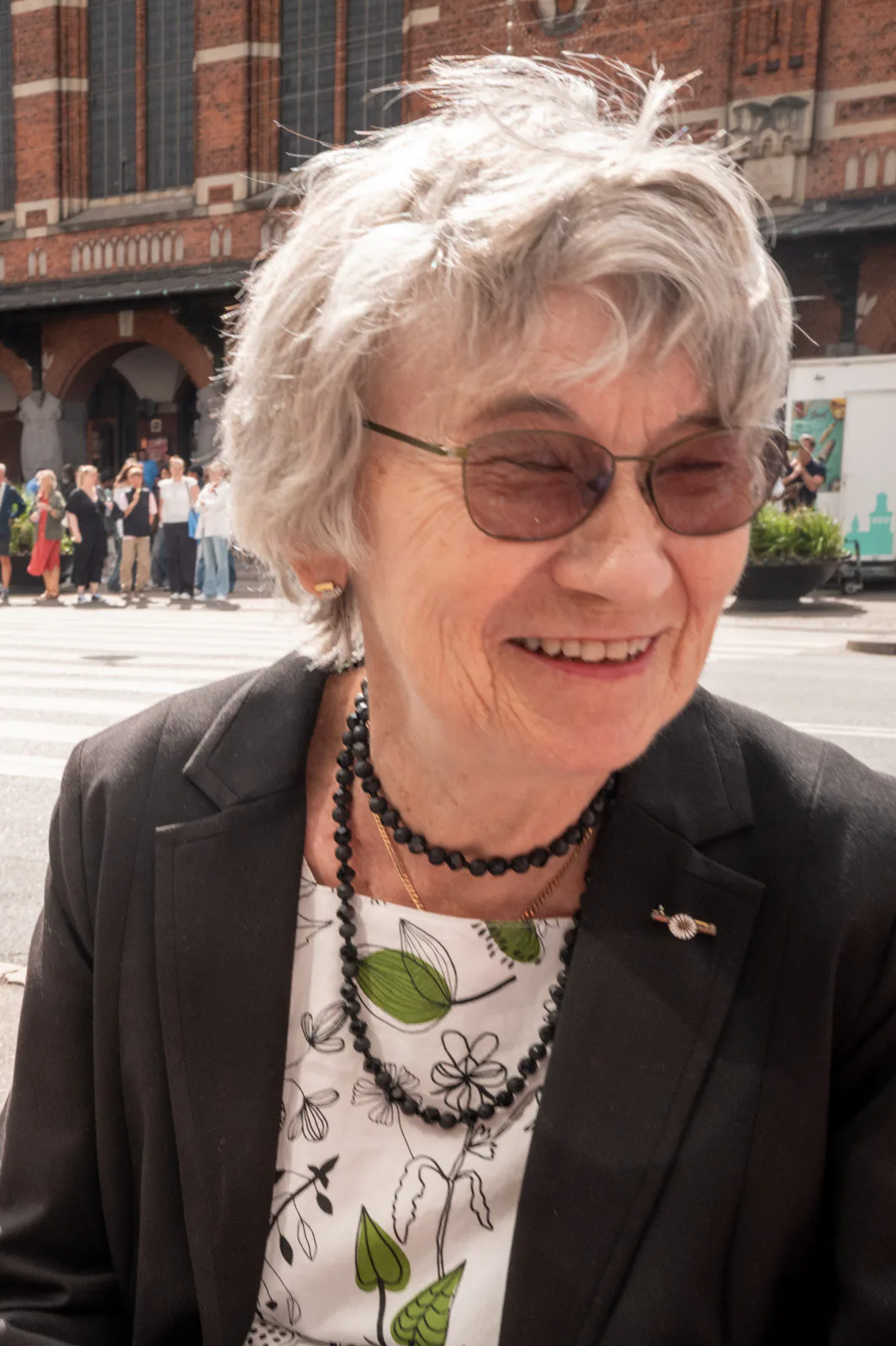 A white-haired lady bursting into laughter behind tinted glasses, Copenhagen