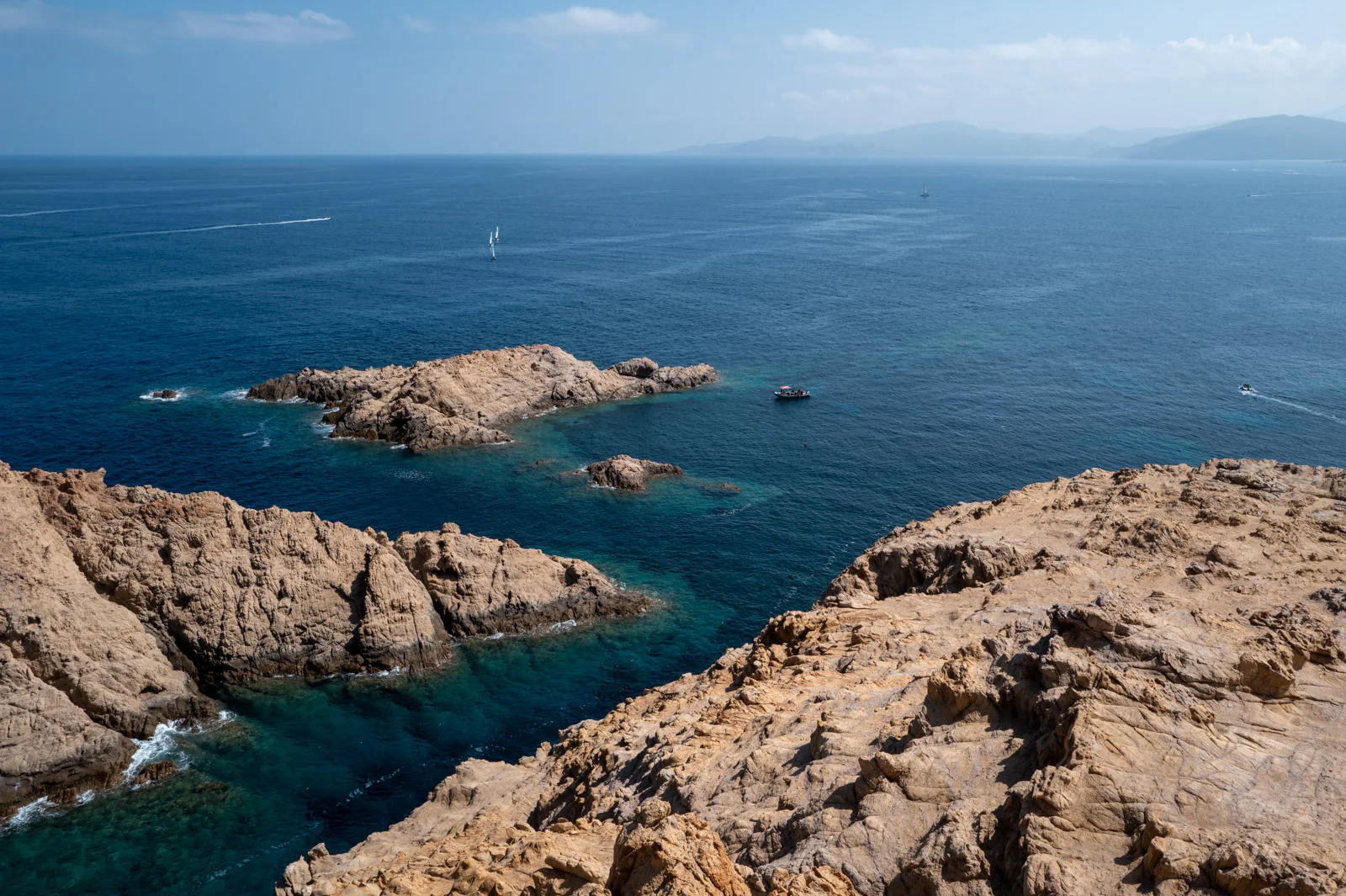 Rochers de granit rouge et îlots dans une eau turquoise, L’Île-Rousse, Corse