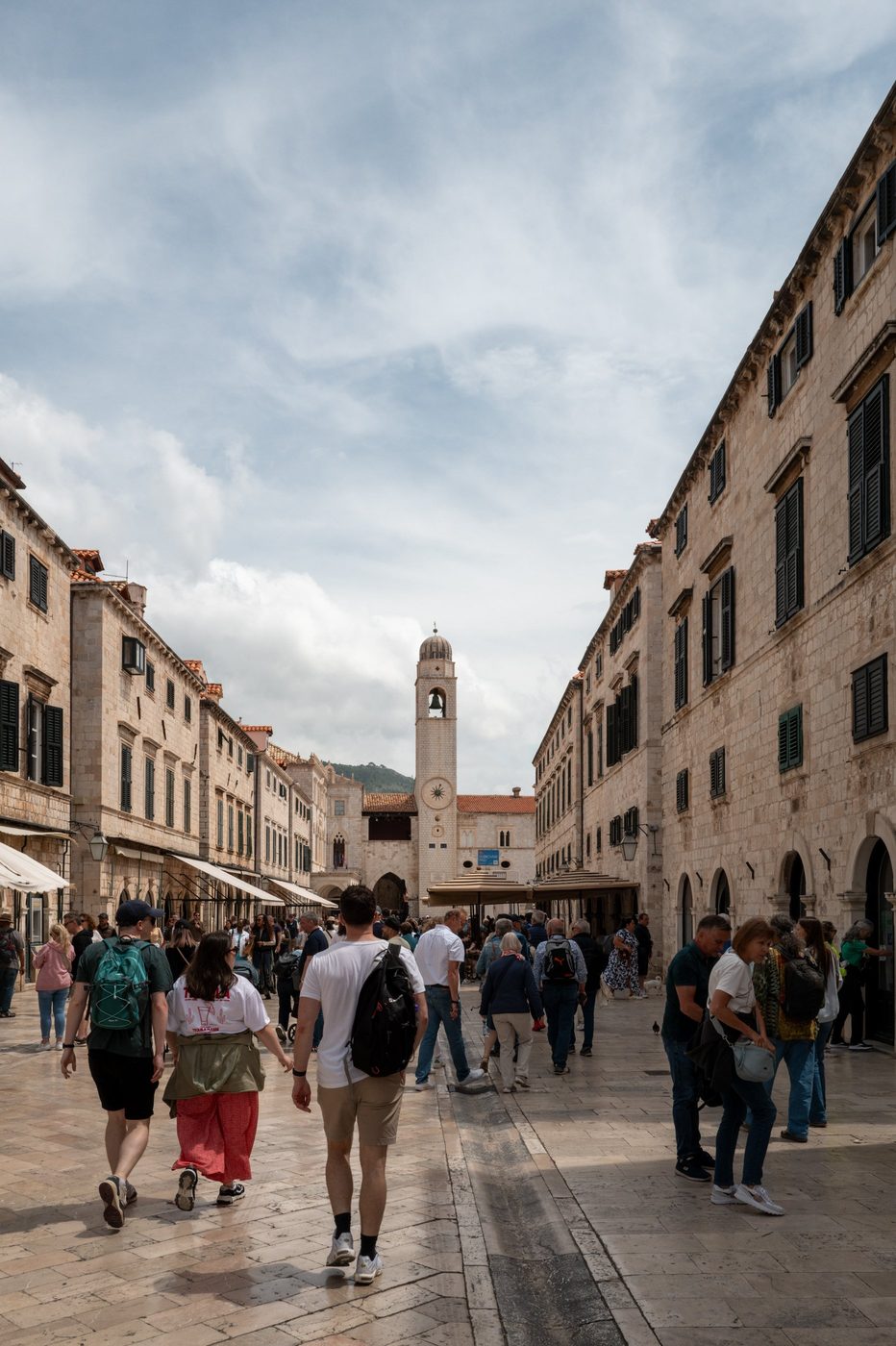 Crowd of tourists walking up the Stradun toward the clock tower, Dubrovnik