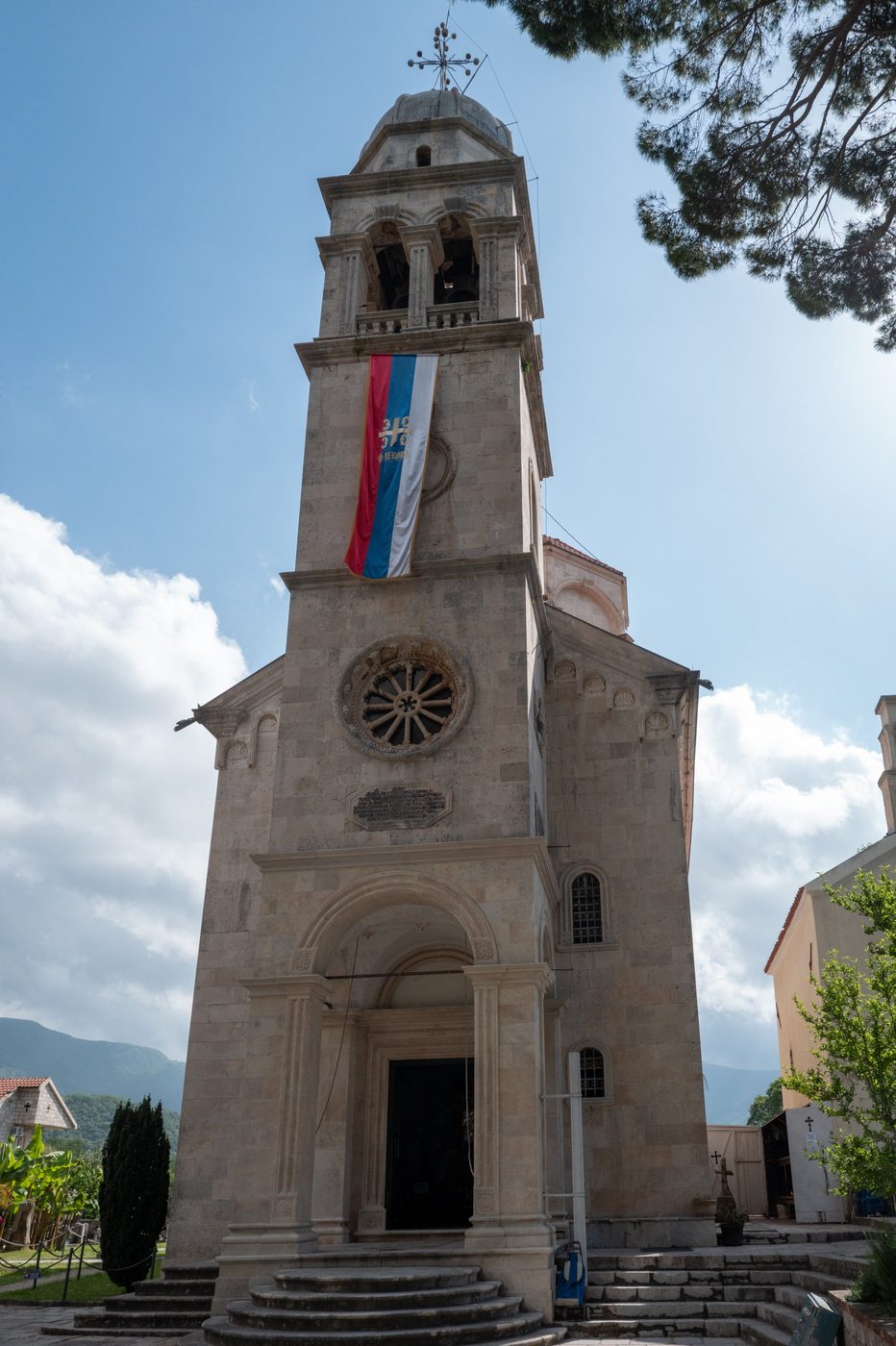 Stone bell tower adorned with a flag against a blue sky, Dubrovnik