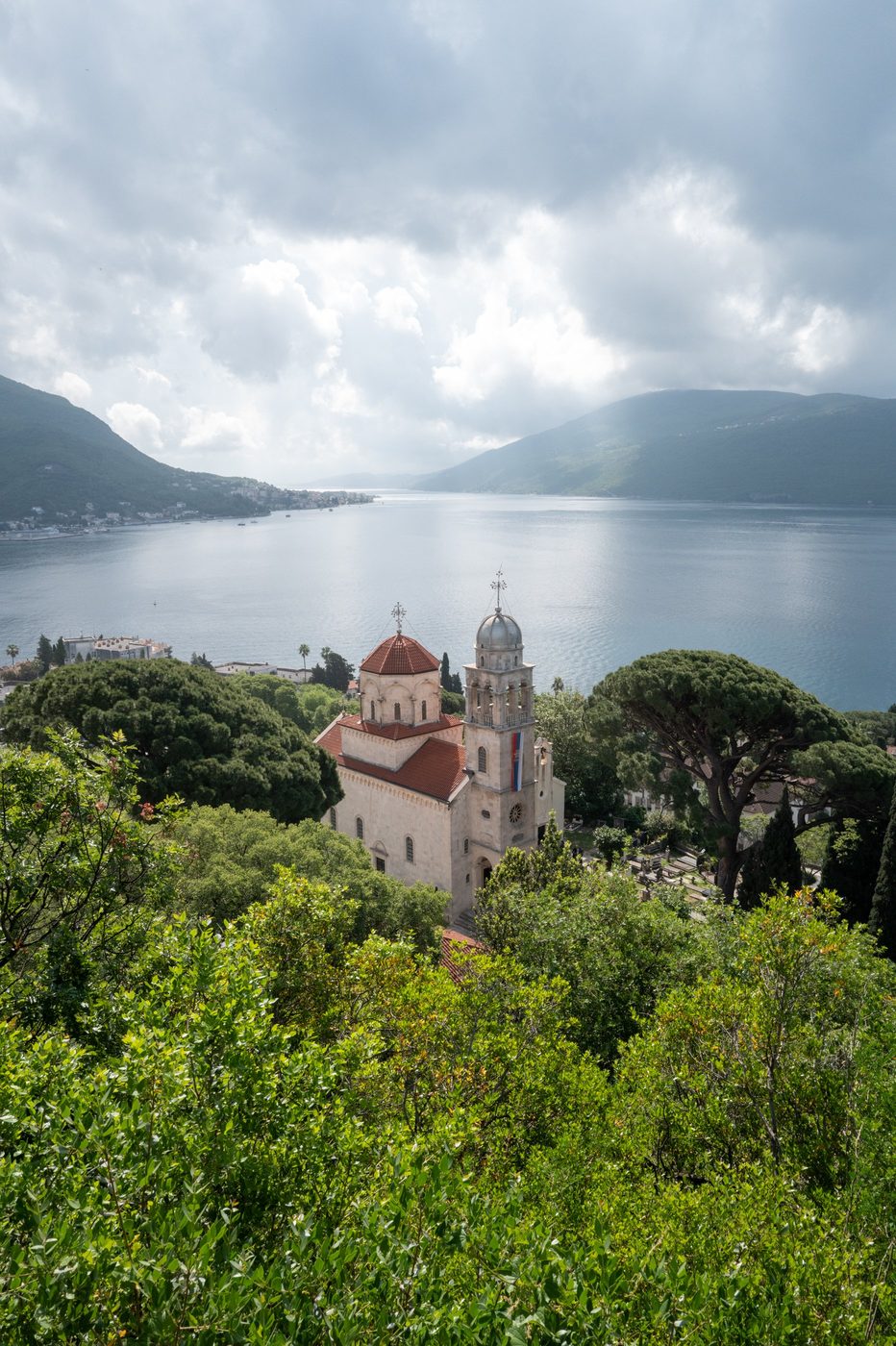 Bell tower and dome of the monastery overlooking the bay under a cloudy sky, Dubrovnik