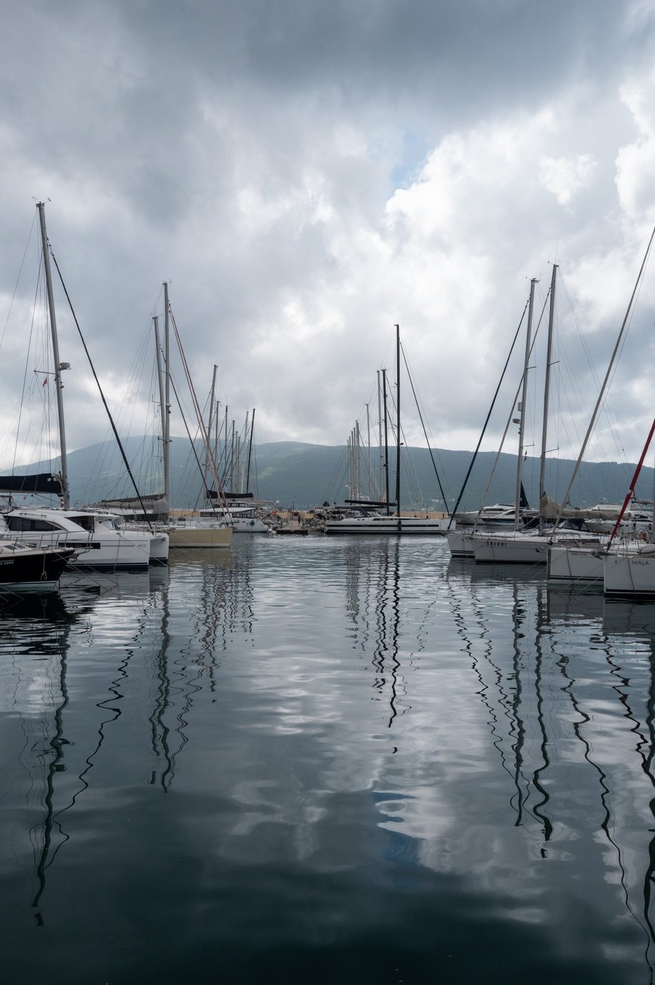 Reflections of sailboat masts in the calm harbor water, Dubrovnik