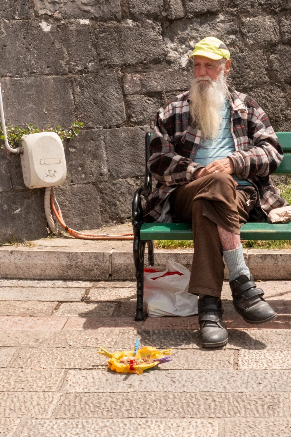 Man with a long white beard sitting near a small makeshift stall, Dubrovnik
