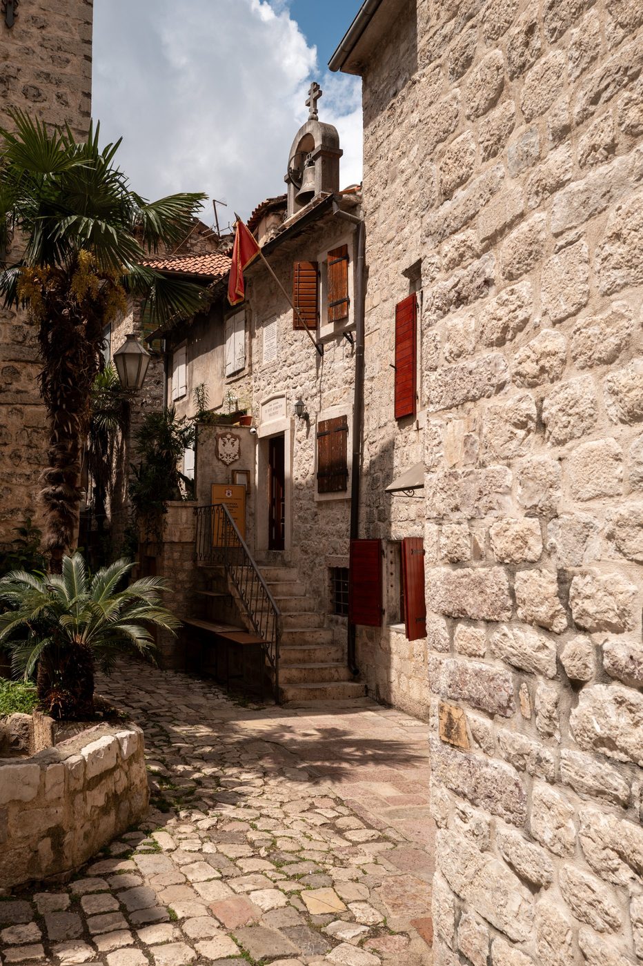 Alley lined with red shutters leading to a small chapel, Dubrovnik
