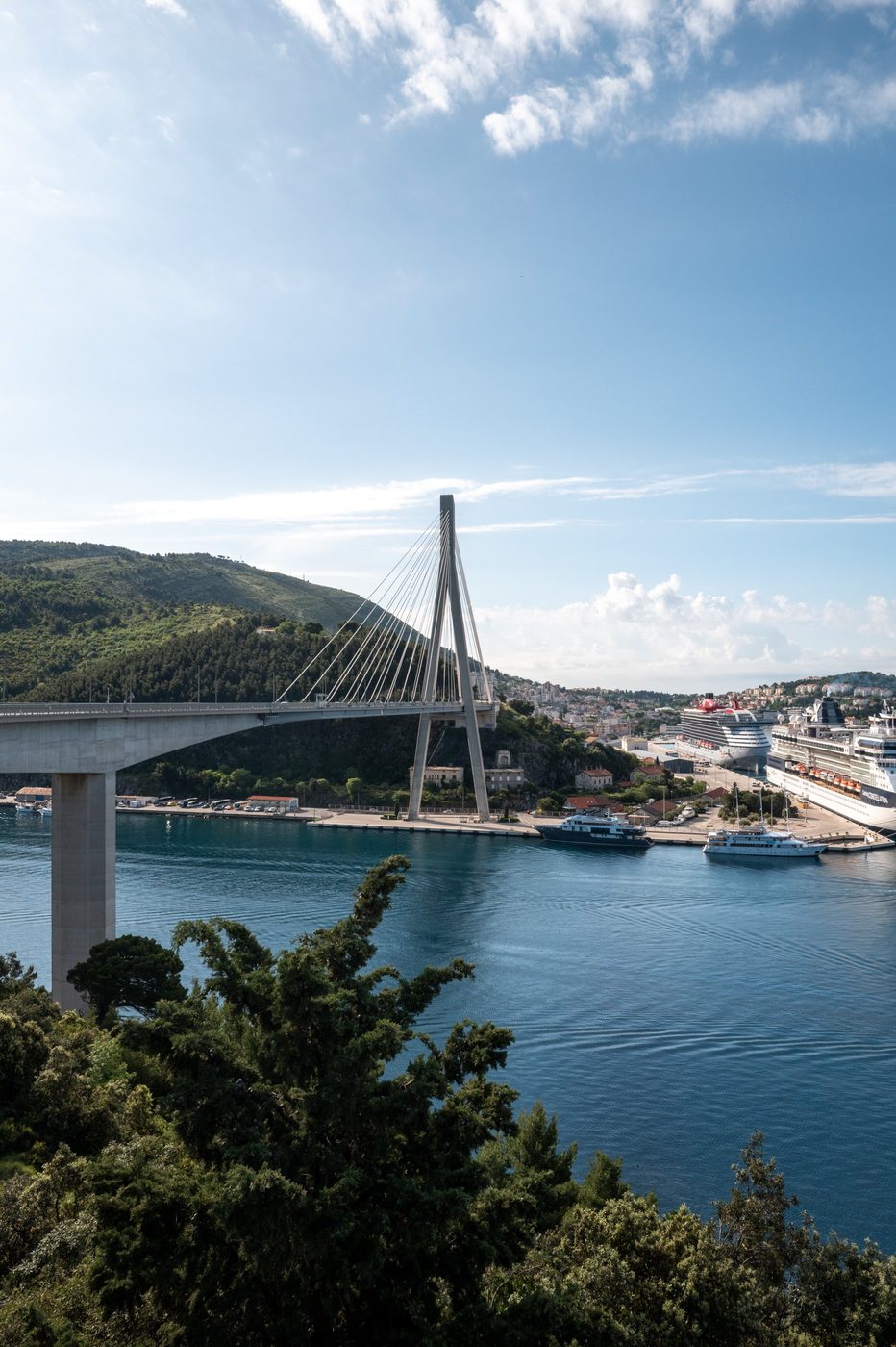 Silhouette of the suspension bridge above a harbor bustling with ships, Dubrovnik