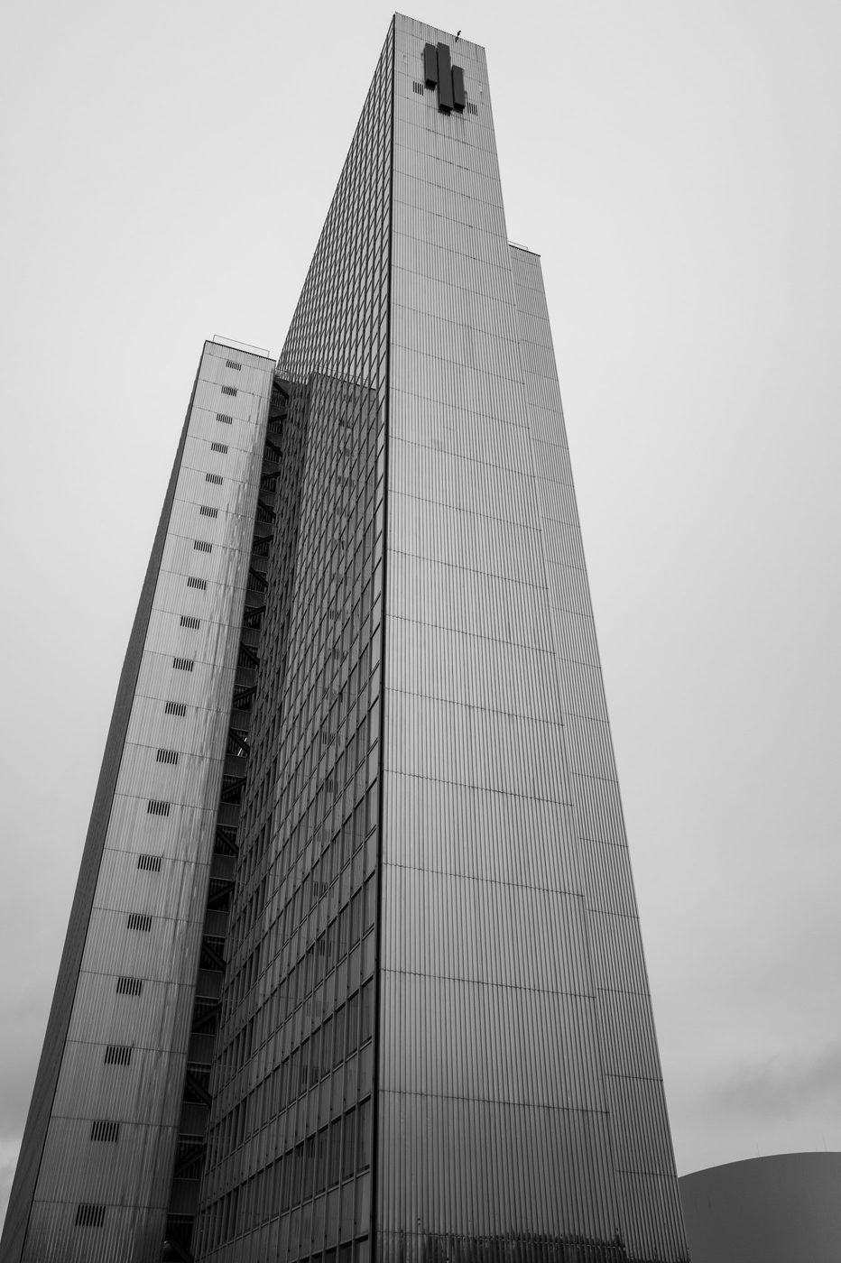 Facade of a dizzying tower seen from below, grey sky, Düsseldorf