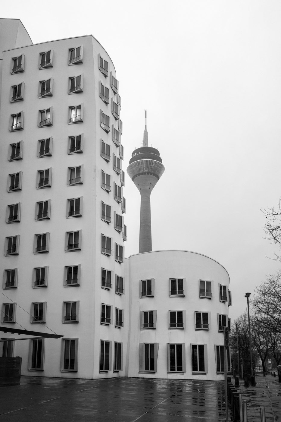 Slender television tower between two curved white buildings, Düsseldorf