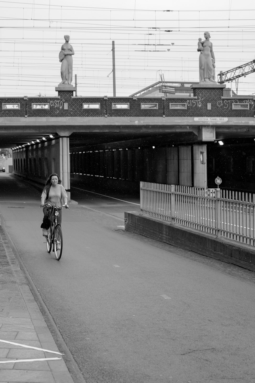 Passage sous un pont orne de statues, cycliste de passage, Eindhoven
