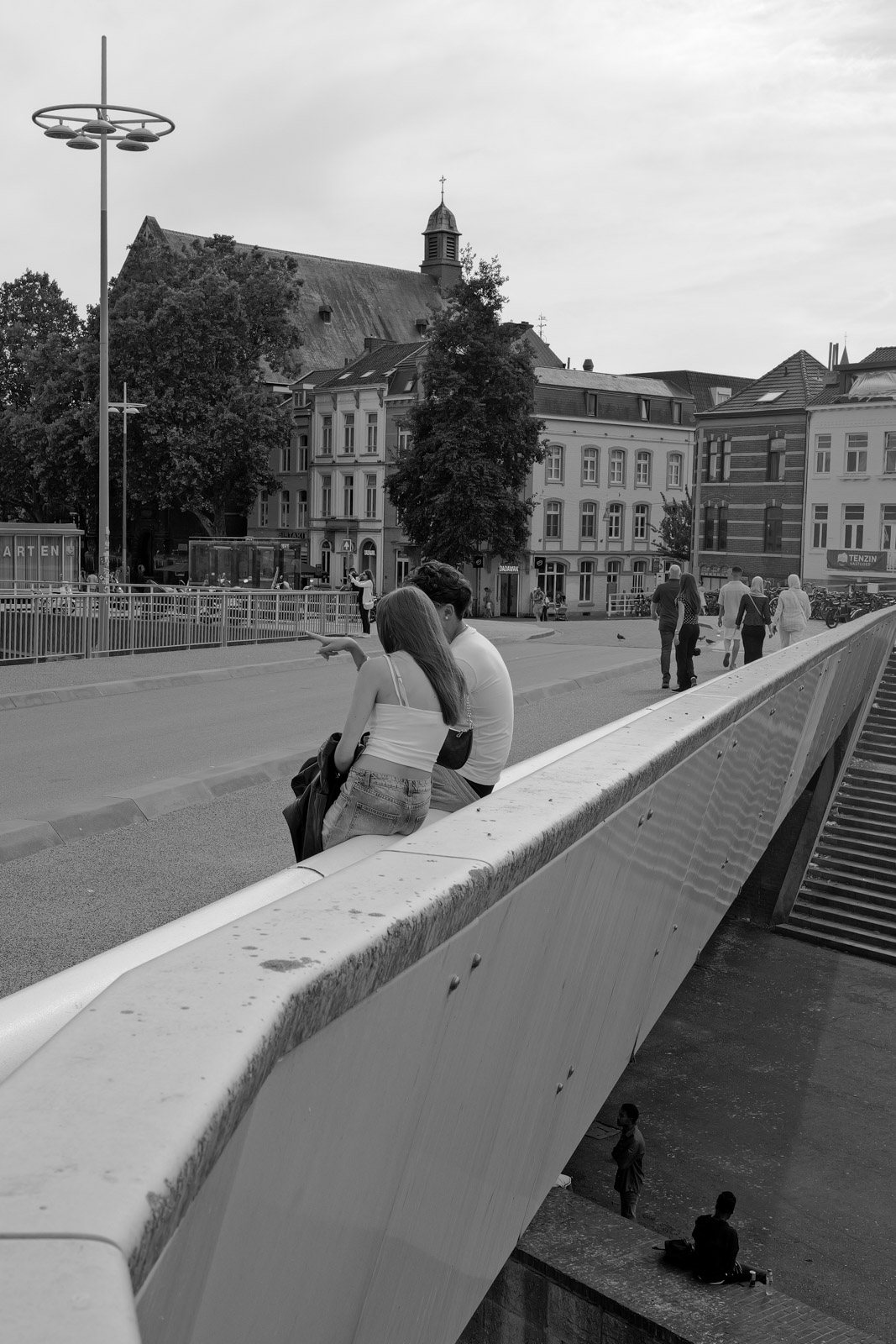Passant assis sur le muret d'un pont au-dessus d'une rue, Eindhoven