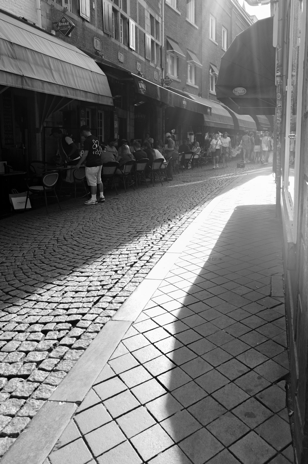 Ruelle pavee ensoleillee bordee de terrasses, Eindhoven