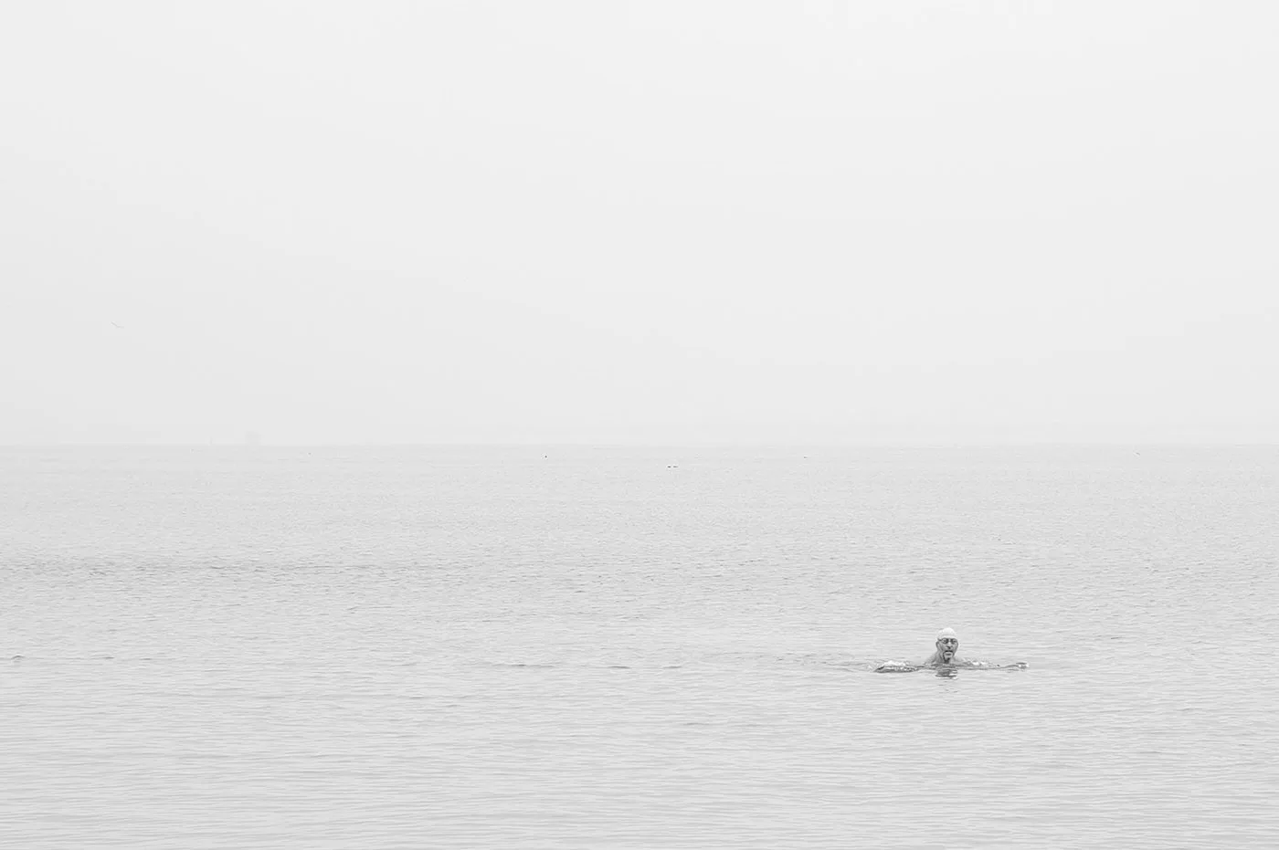 La tête d’un nageur dans une mer immense et grise, Coney Island, New York